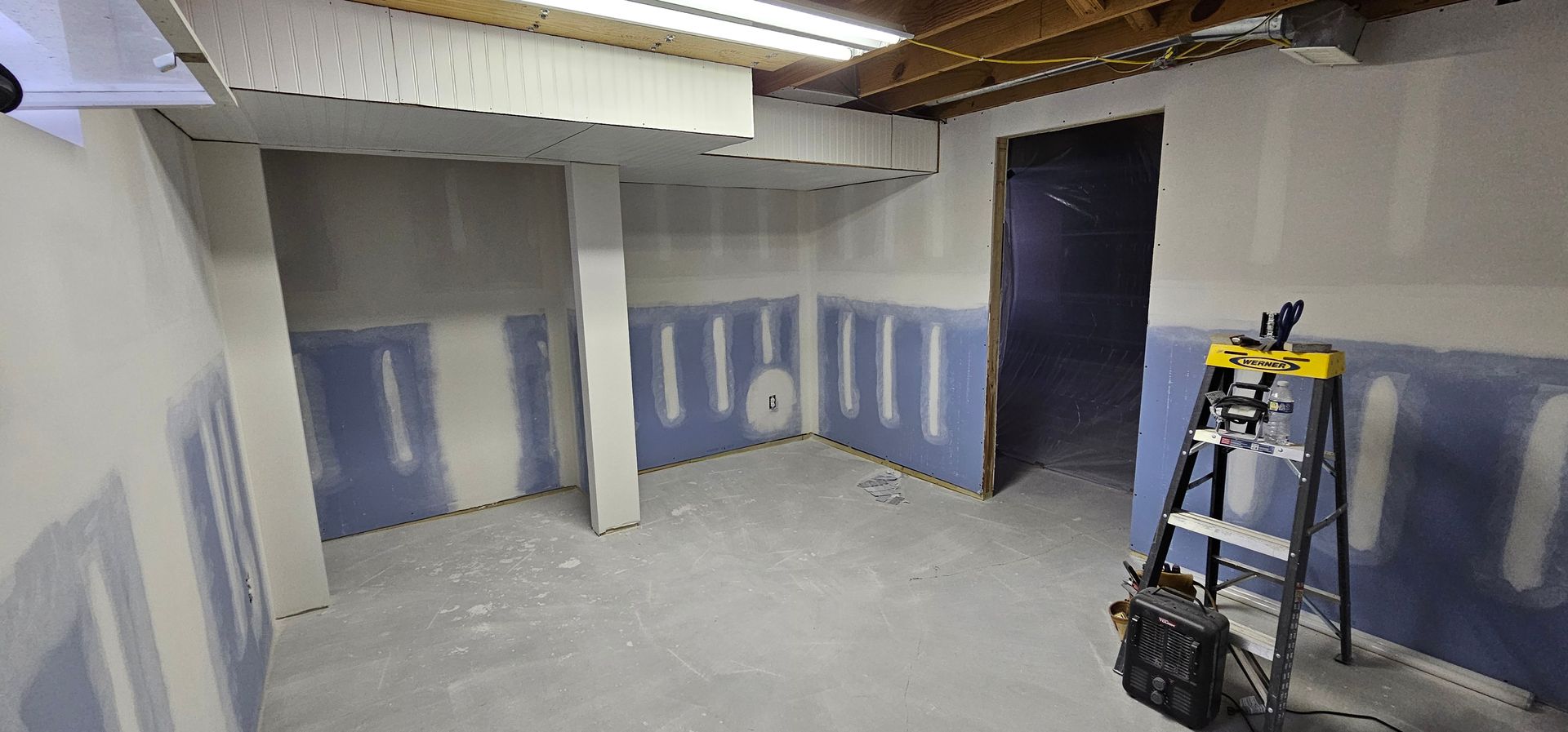 Empty black-painted room with carpeted floor, open doorways, and overhead lights