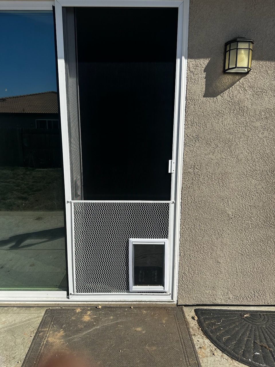 A sliding glass door with a dog door attached to it.
