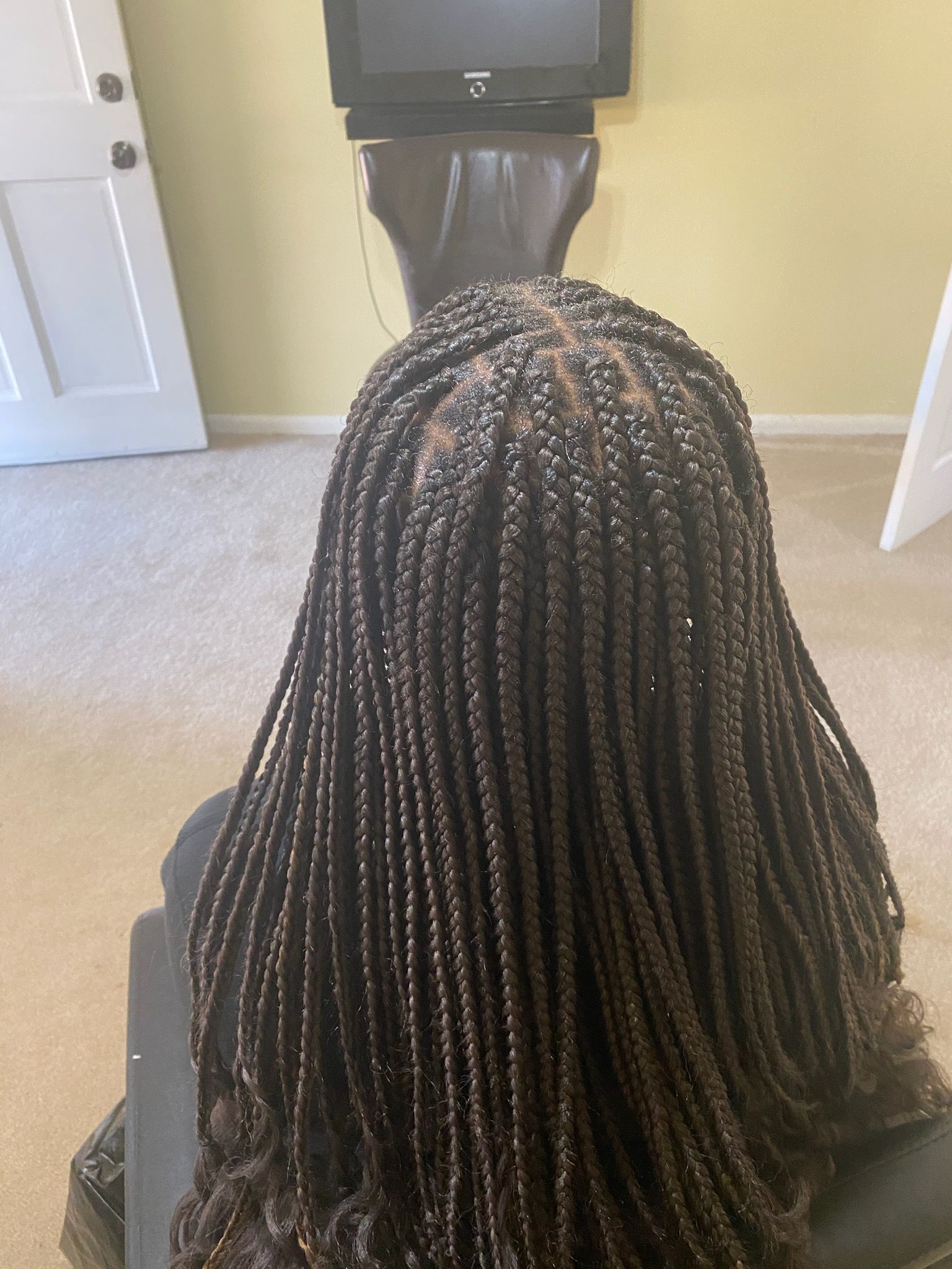 A Woman With Braids Is Sitting In Front Of A Television | Fayetteville, NC | Fatouisa African Braiding
