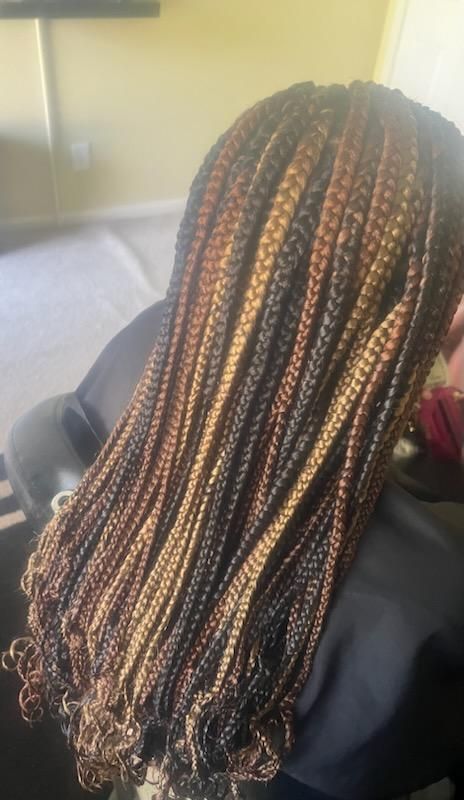 A Woman With Braids In Her Hair Is Sitting In A Chair | Fayetteville, NC | Fatouisa African Braiding