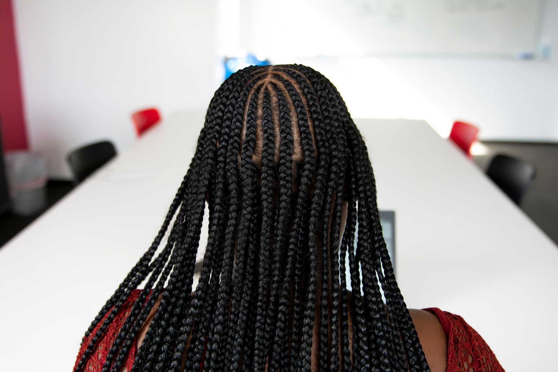 a woman with braids is sitting in front of a white table