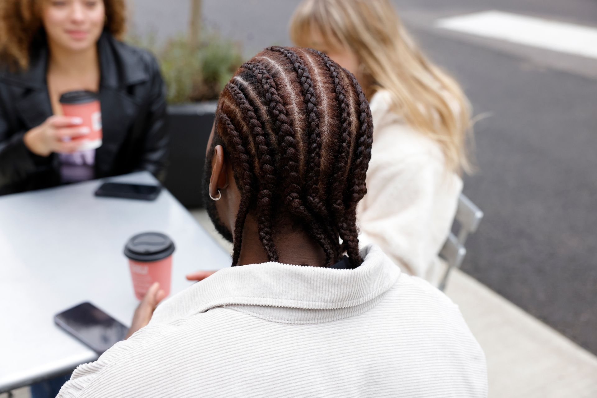 A Woman With Braids Is Sitting At A Table With Two Other Women | Fayetteville, NC | Fatouisa African Braiding