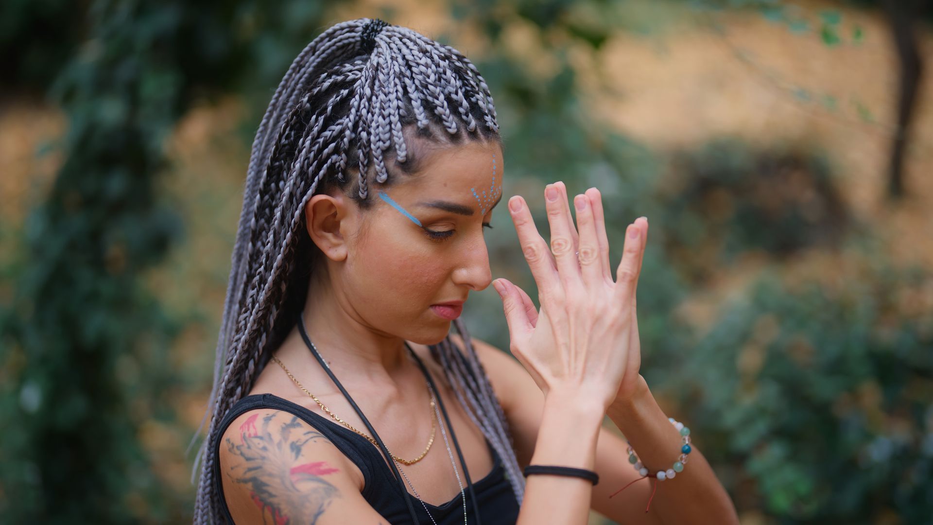 A Woman With Braids Is Praying With Her Hands Together | Fayetteville, NC | Fatouisa African Braiding