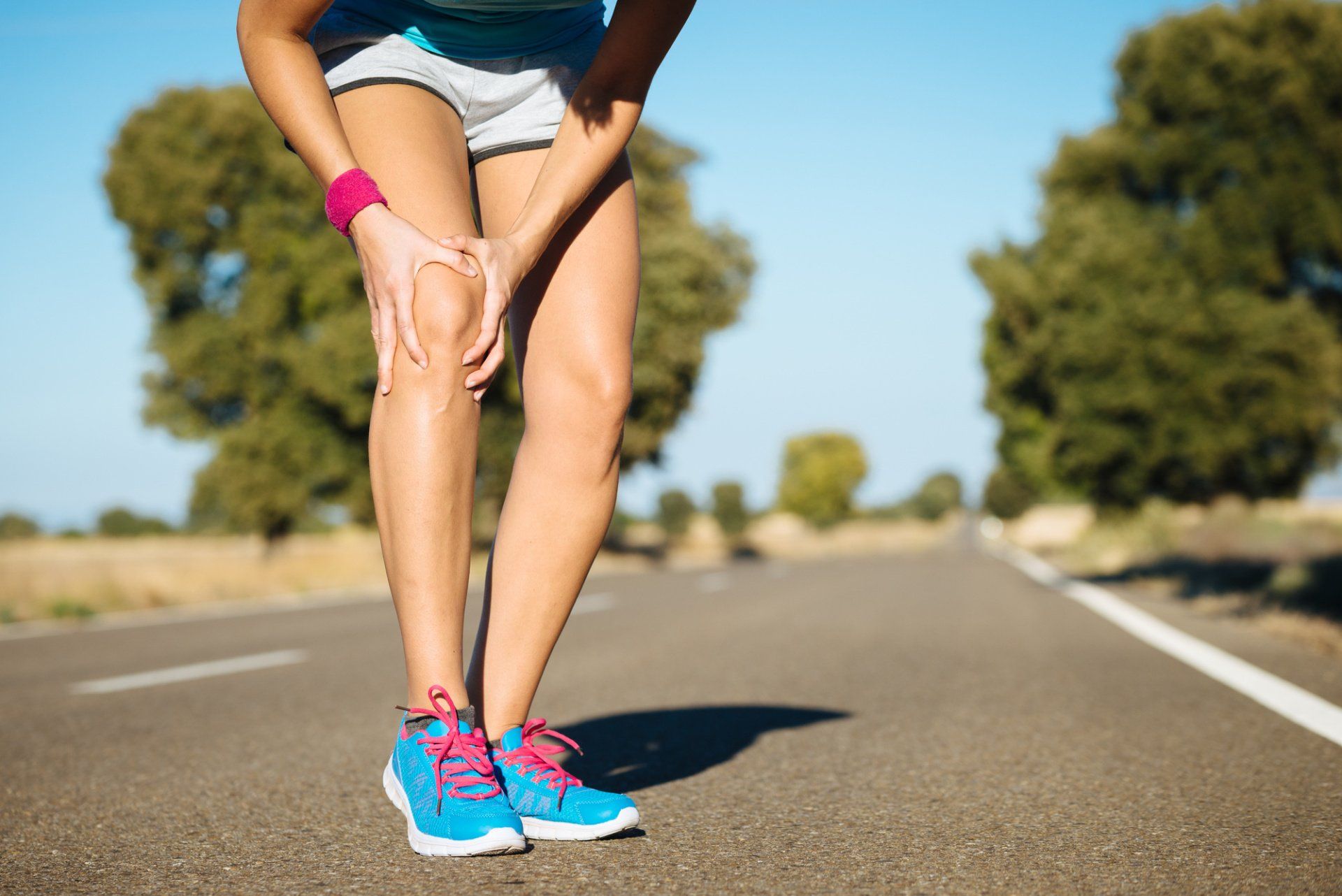 lady with injured knee stops while running