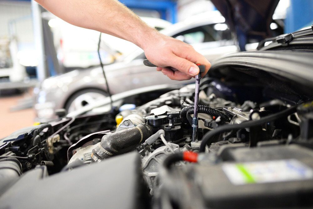 Mechanic Working on Car Engine in a Garage With a Screwdriver — Resurge Diesel & Fabrication Pty Ltd In Balnagowan, QLD