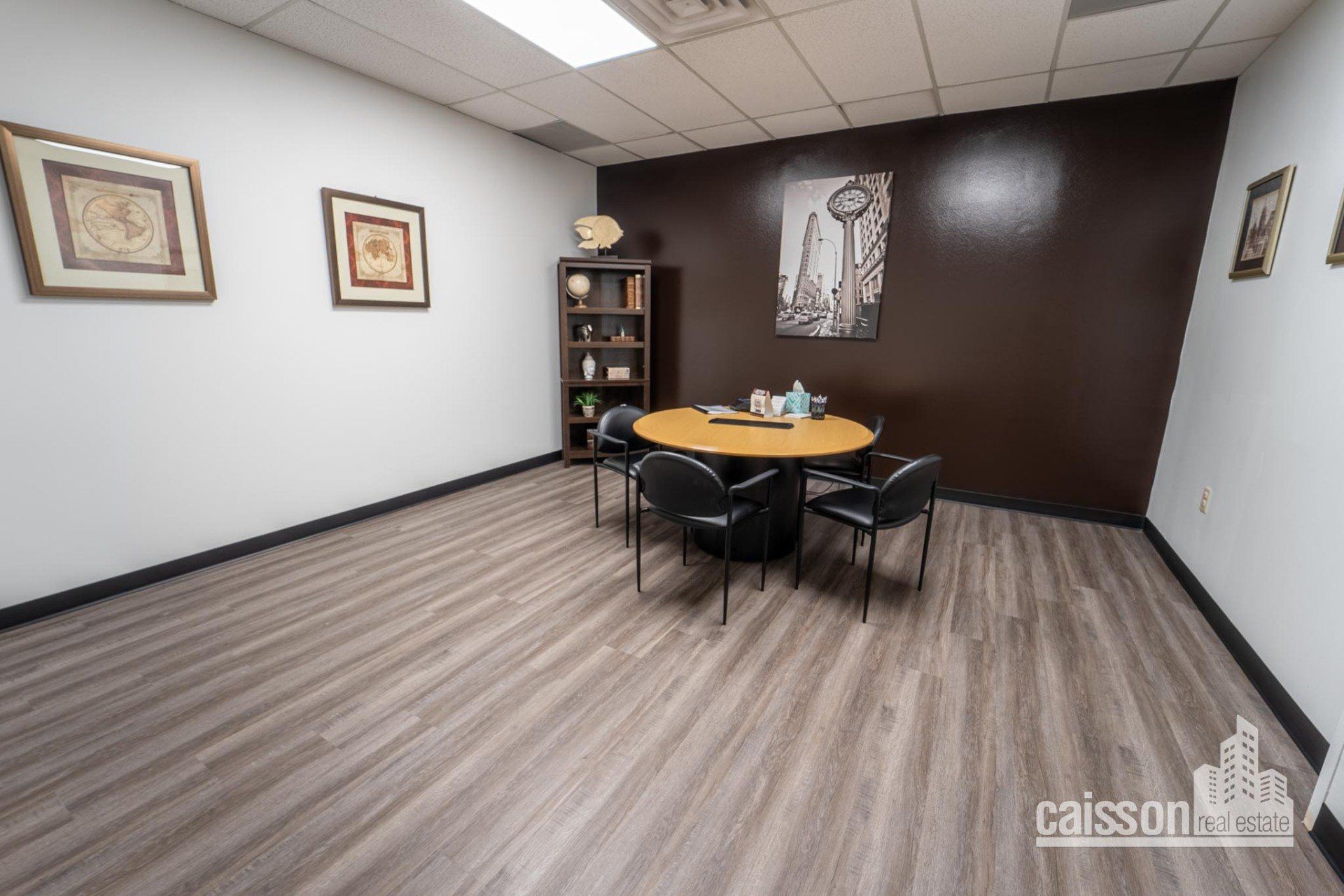 Interior view of suite with grey flooring round table with chairs.