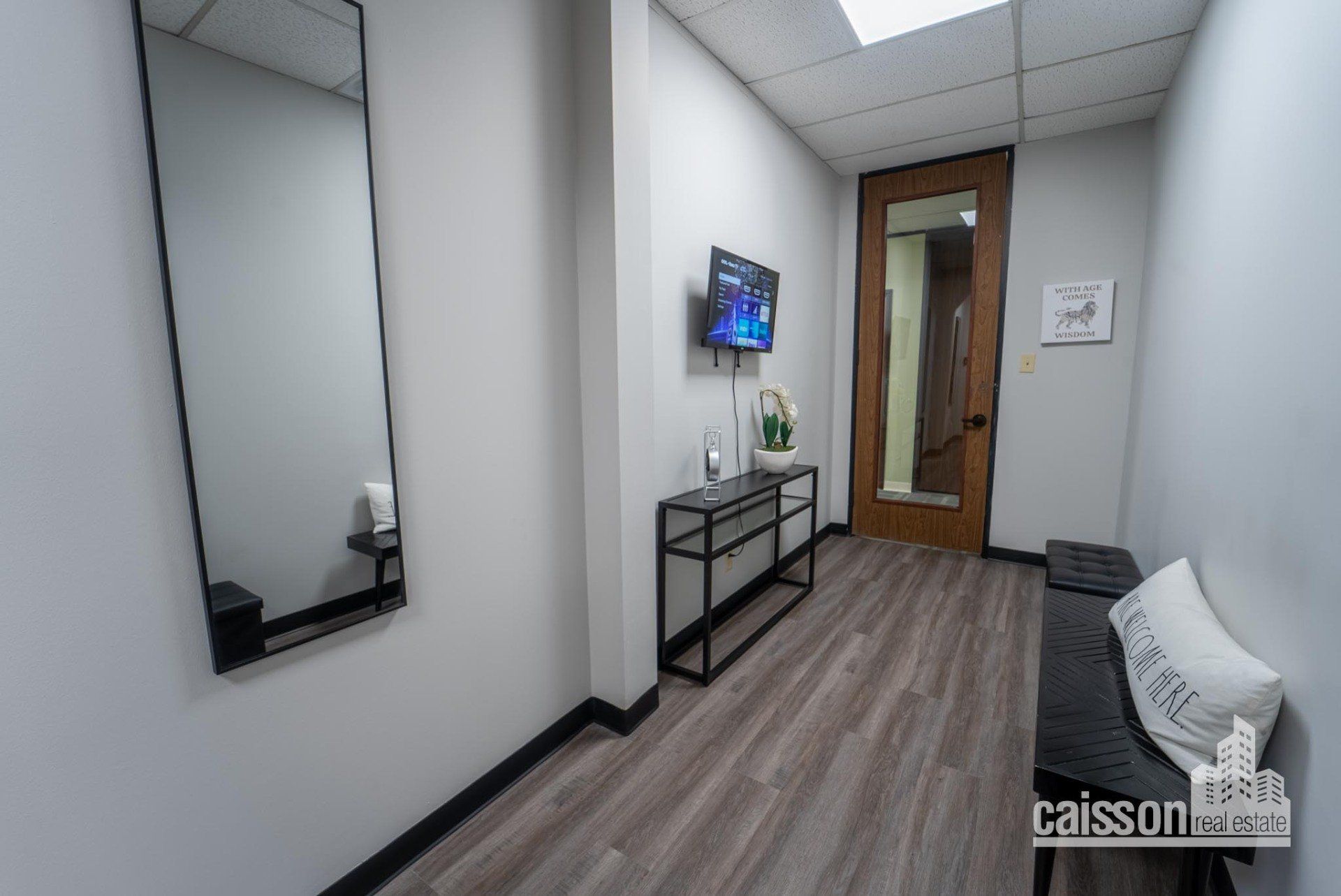 Interior view of lobby in suite with couch and grey flooring.