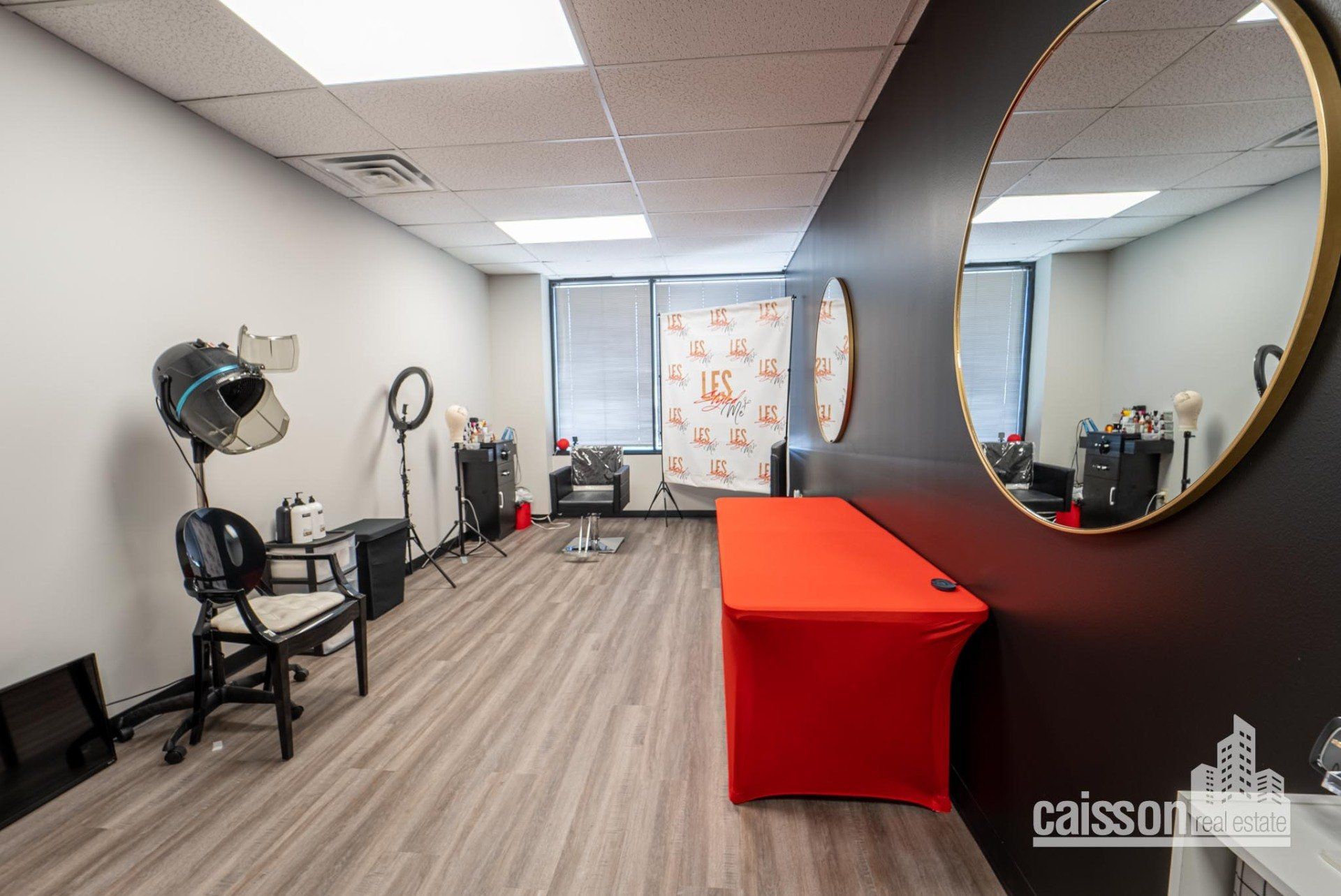 Interior view of suite for salon with grey flooring, barber chair and hair dryer