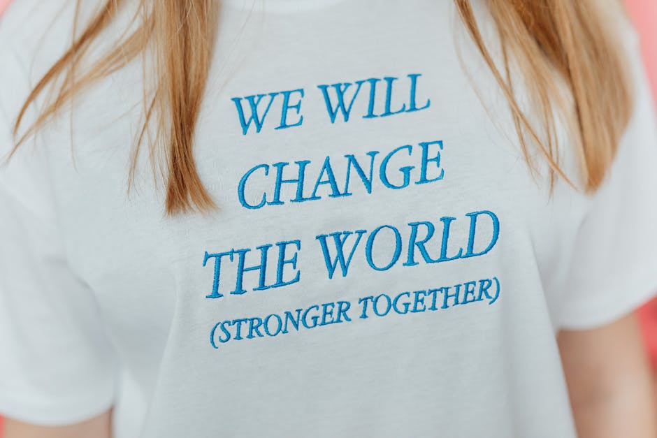 A girl wearing a t-shirt written on it: we will change the world (Stronger Together)