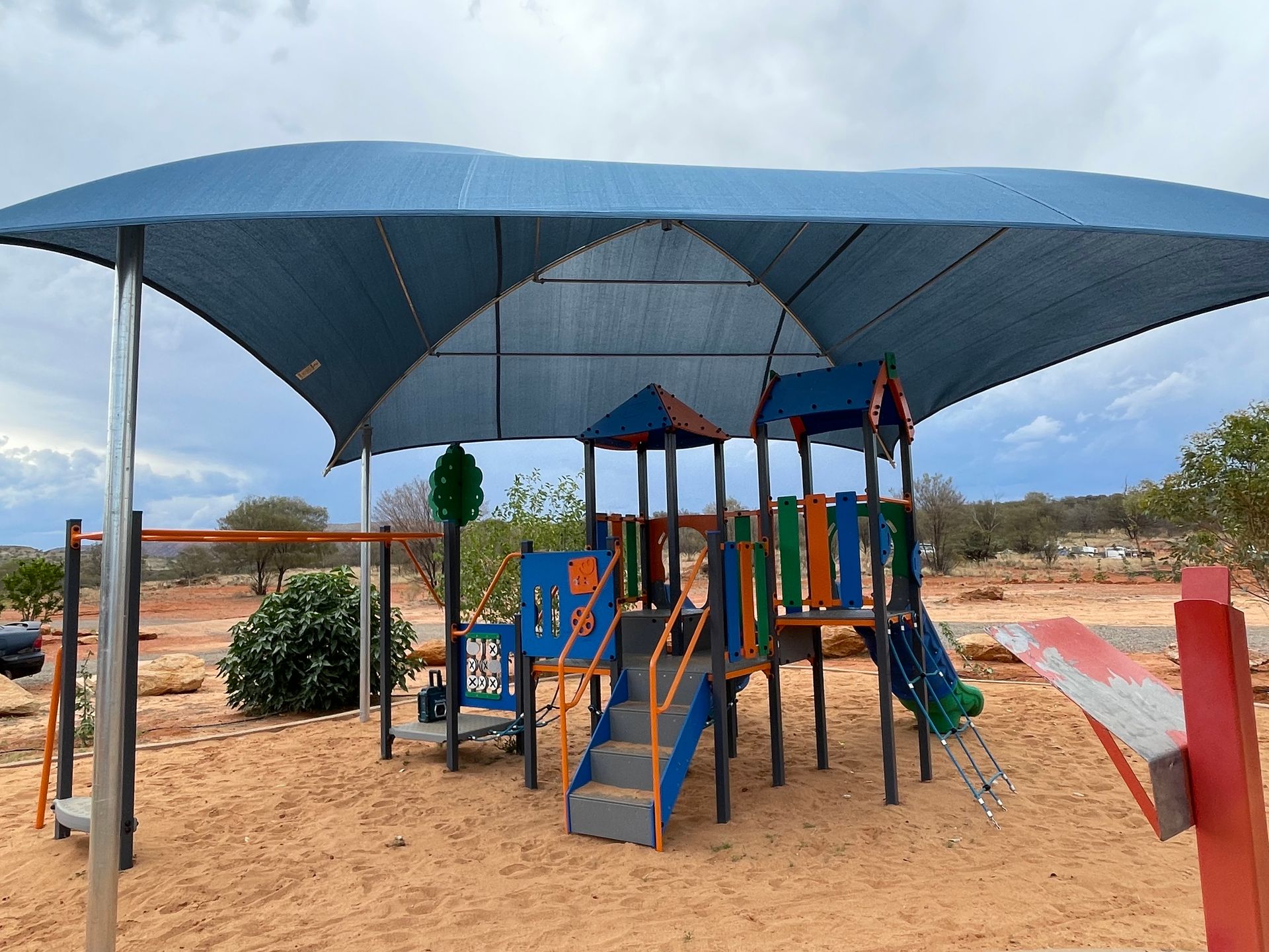A Large Blue Shade Sail Is Covering A Playground — Shadetech in Alice in Ciccone, NT