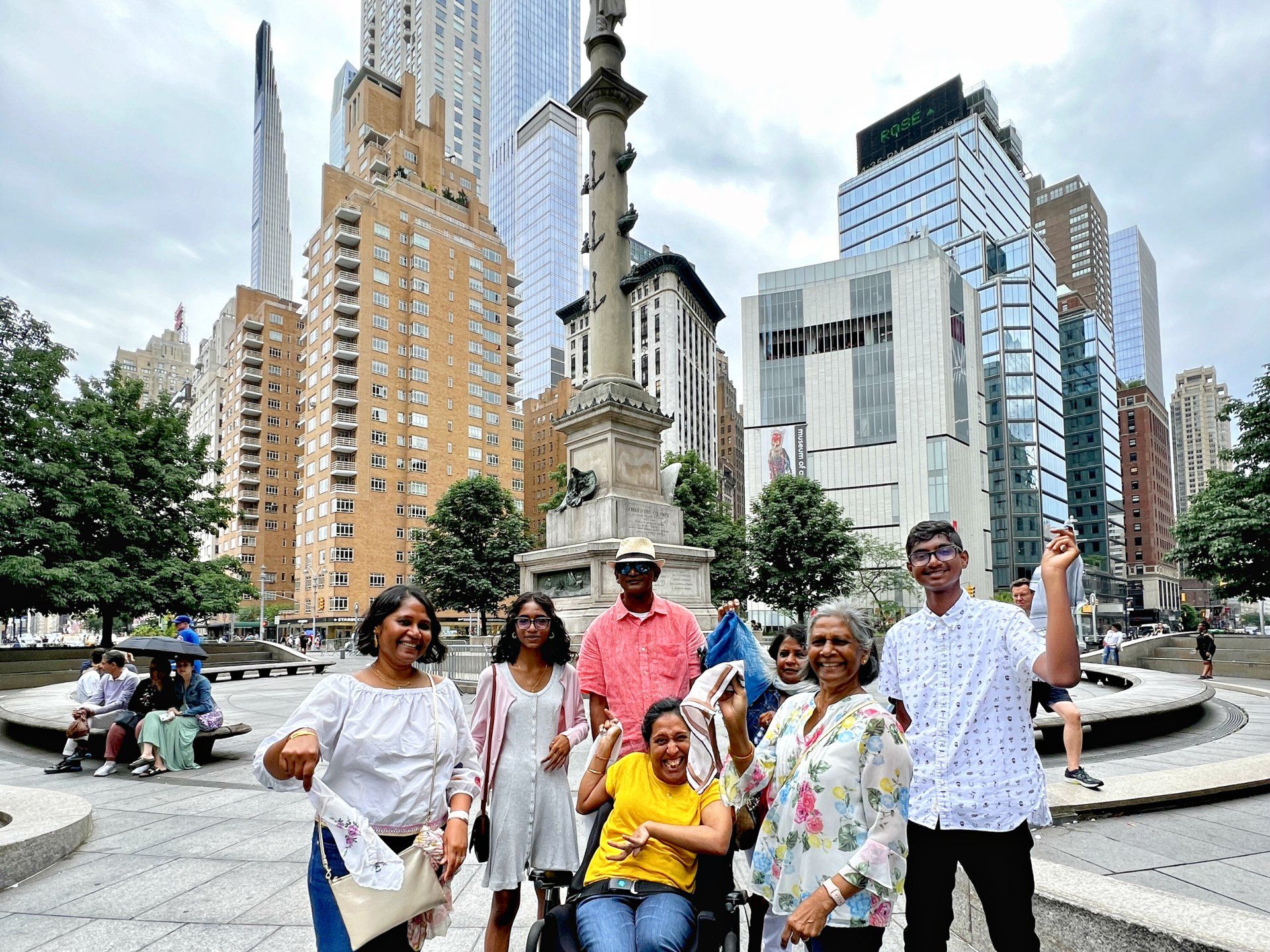 Our family of six, plus our aunt, all at Columbus Circle.  We're dressed colorfully, a cloudy day, holding up our kerchiefs while waiting for the Jazz Procession.