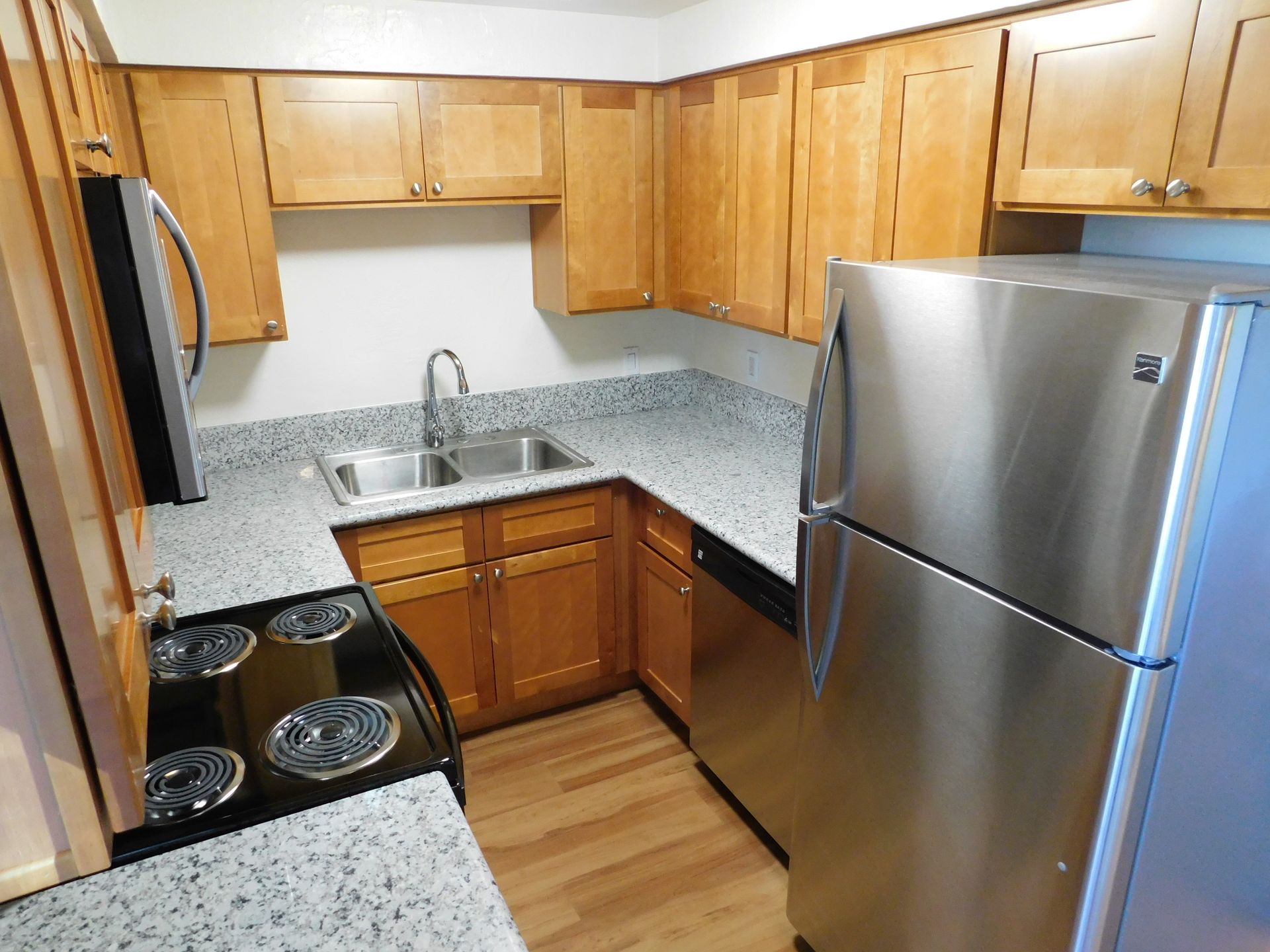 Kitchen with wooden cabinets, stainless steel appliances, and gray countertops.