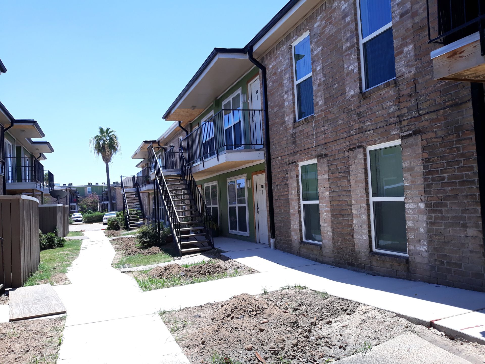 A brick apartment building with stairs leading up to the second floor