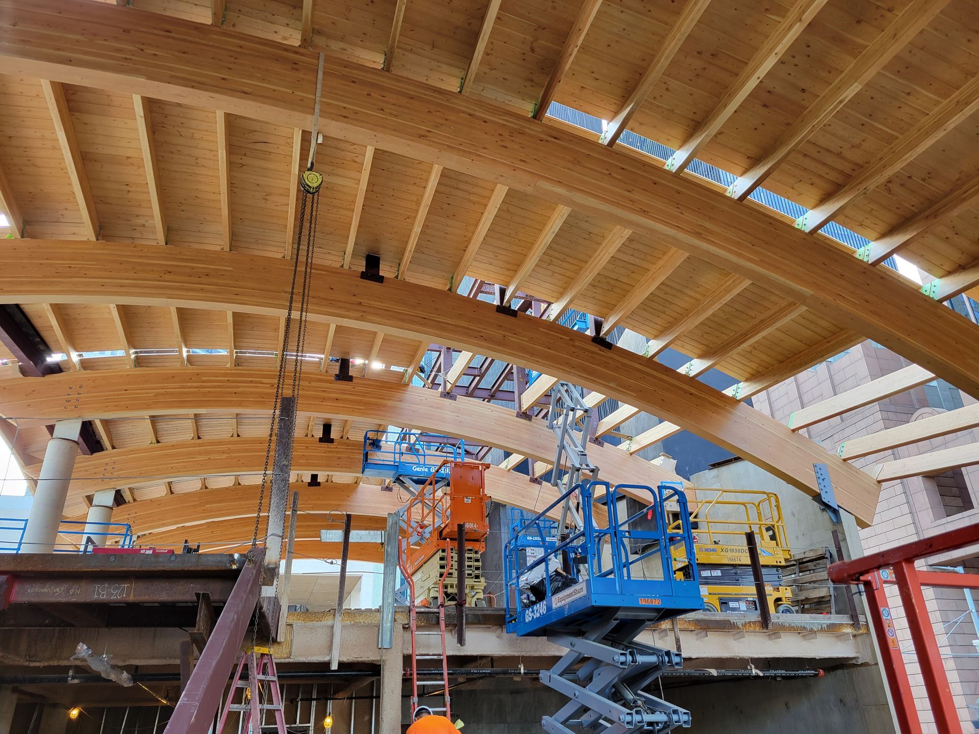 A construction site with a lot of wooden beams and a lift.