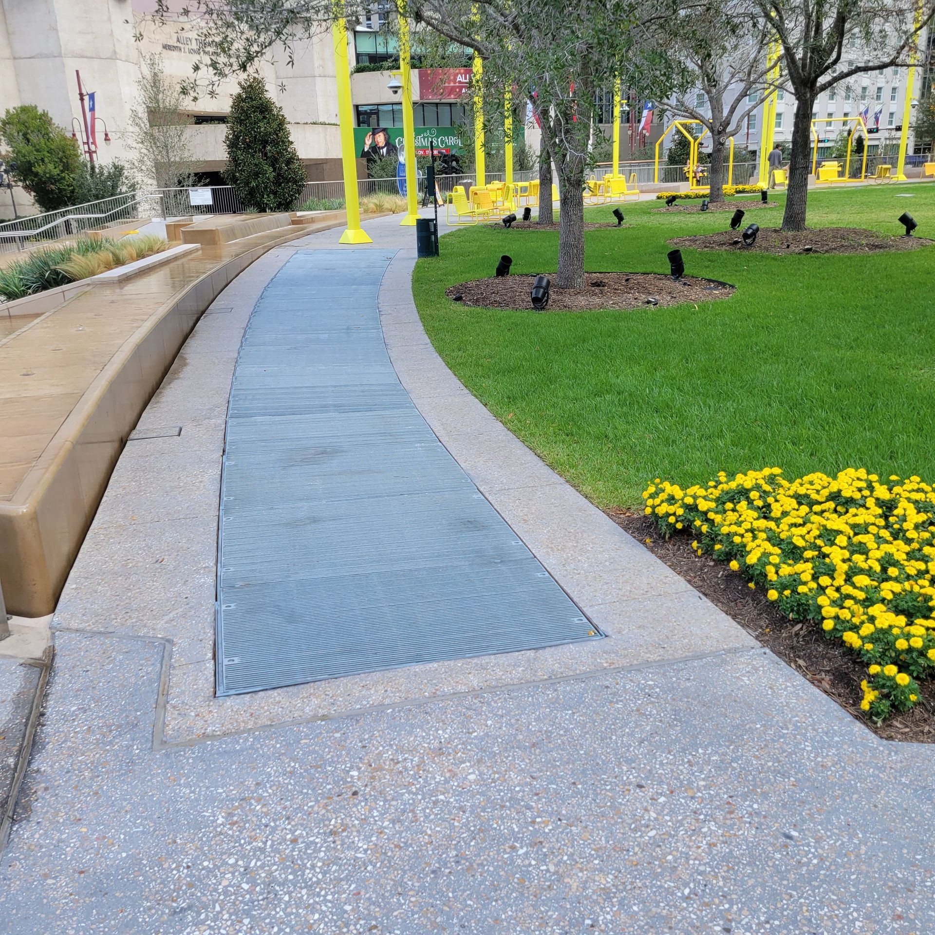 A walkway in a park with flowers and trees