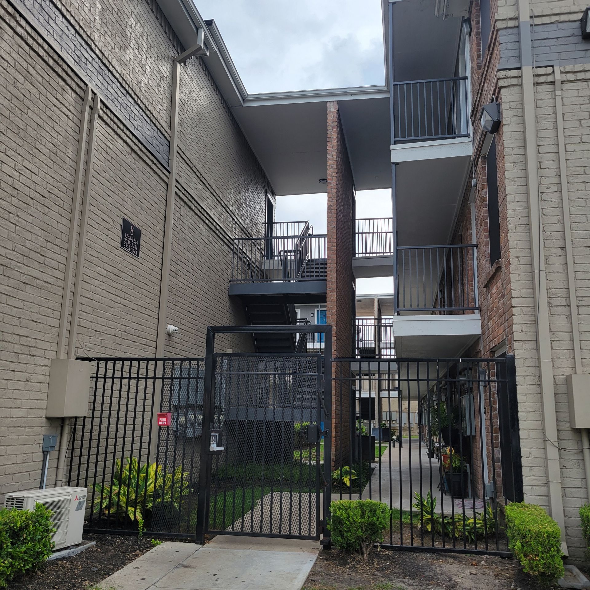 A brick building with stairs leading up to the second floor