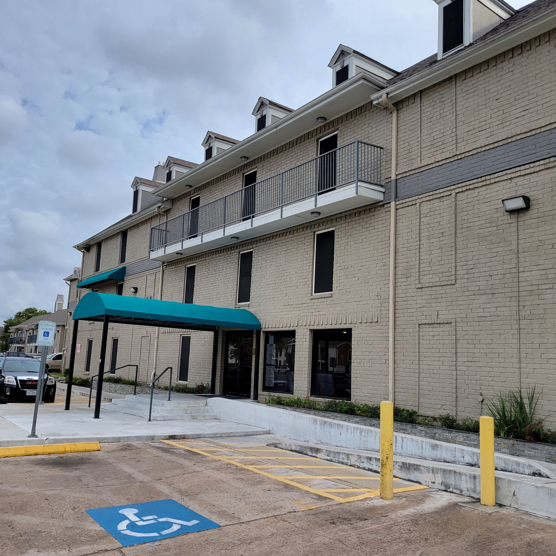 A large brick building with a handicapped parking spot in front of it