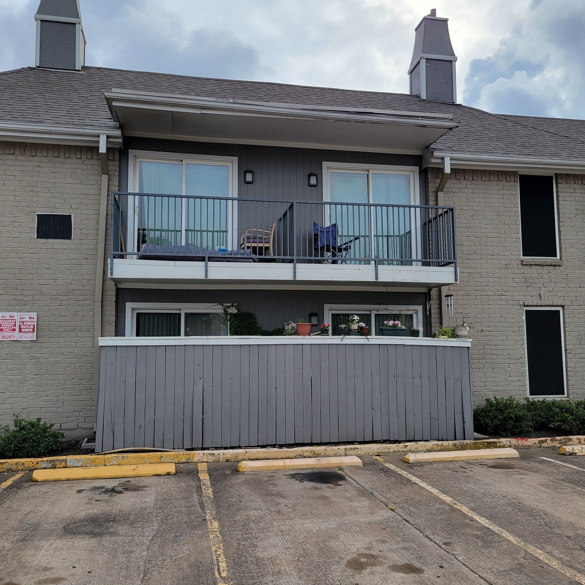 A building with a balcony and a sign that says no parking
