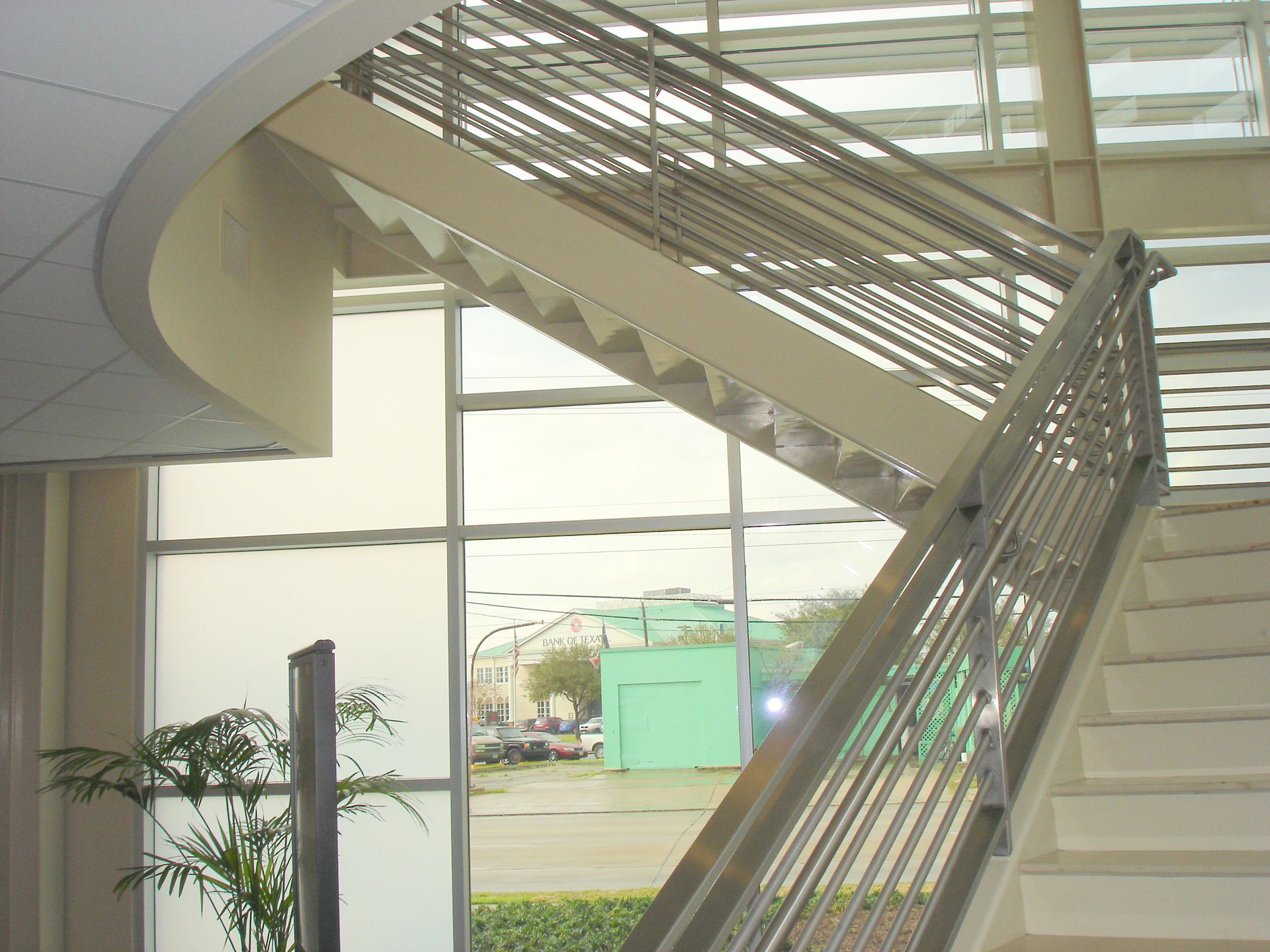 A staircase in a building with a stainless steel railing
