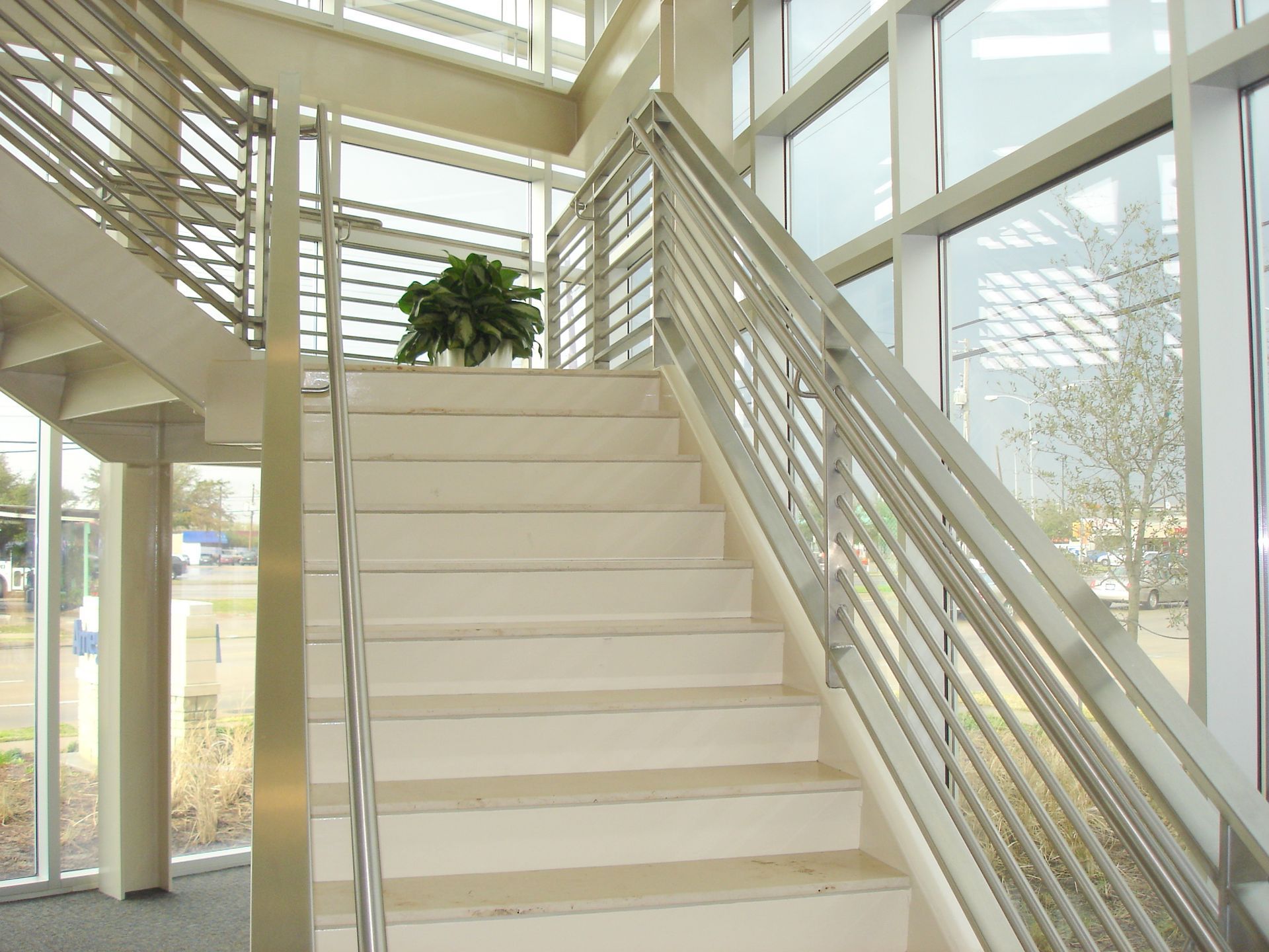 A staircase in a building with a stainless steel railing