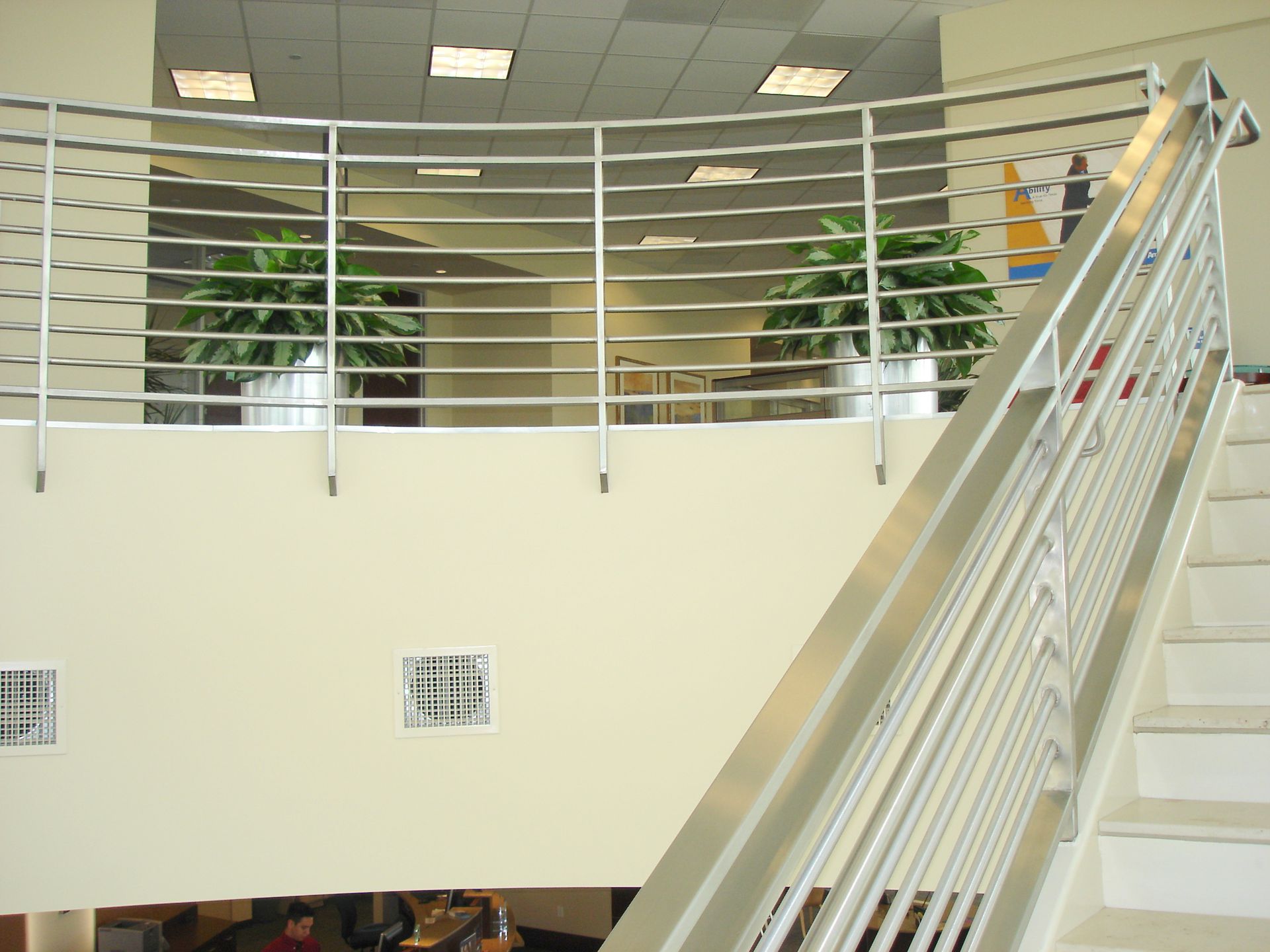 A staircase with a stainless steel railing leading up to the second floor