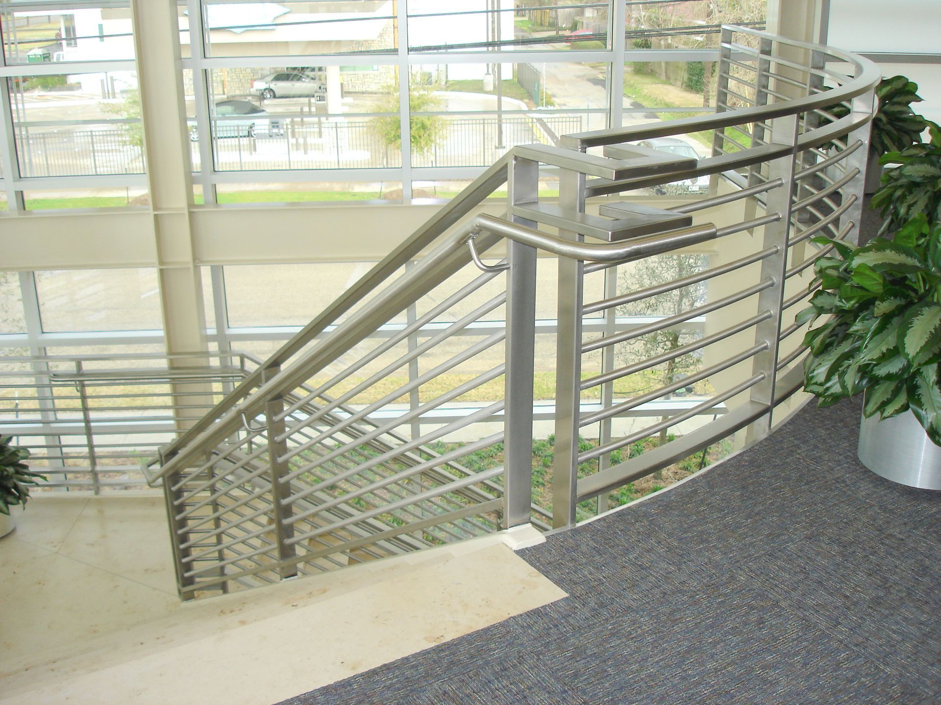 A staircase with a stainless steel railing in a building