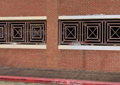 A brick building with a metal fence around the windows