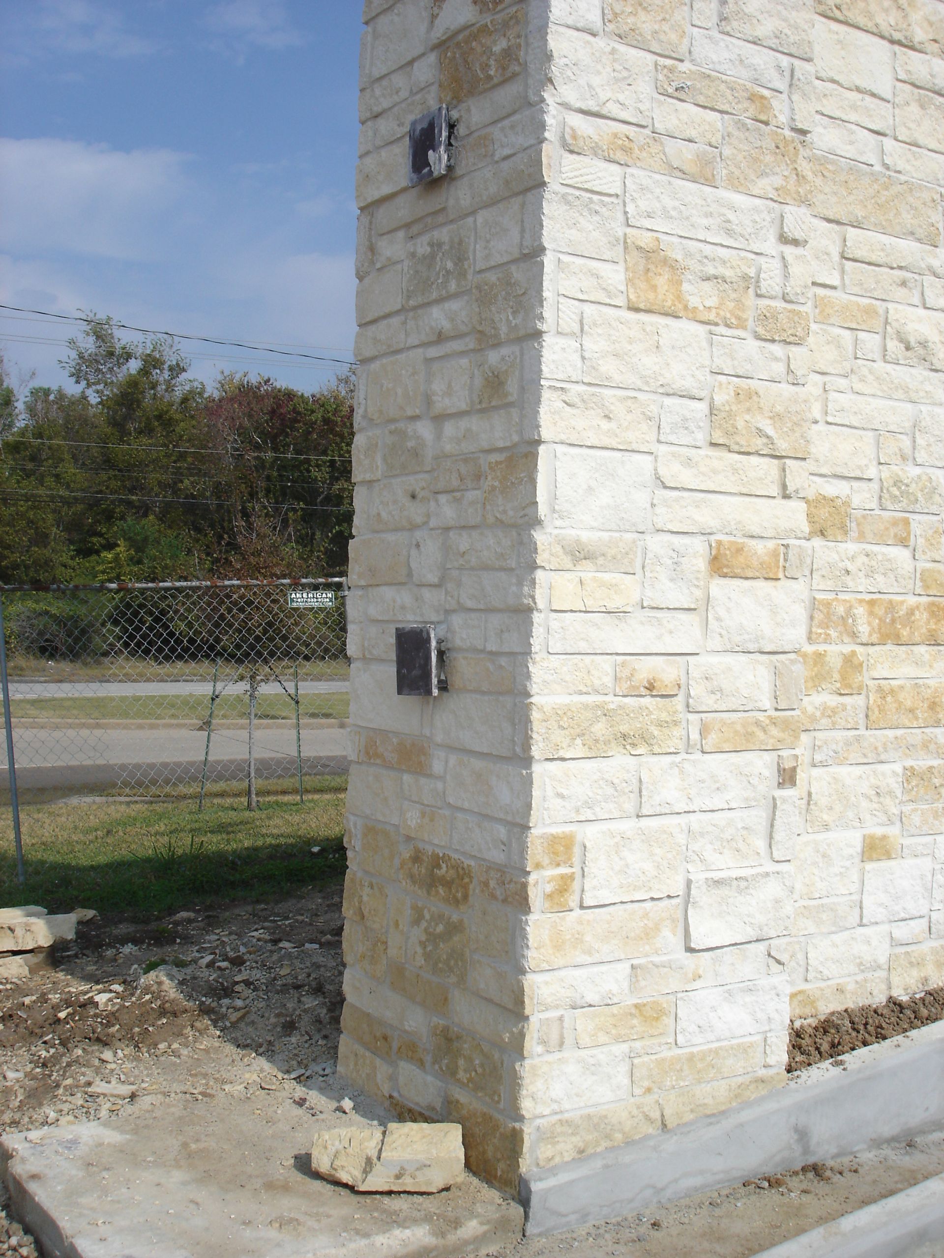 The corner of a brick building with a sign on it