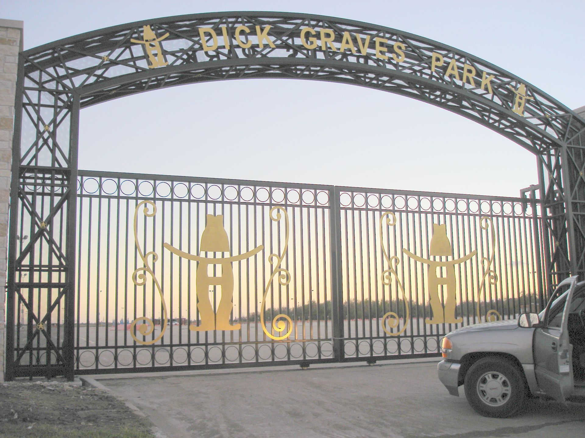 A car is parked in front of a gate that says park graves park