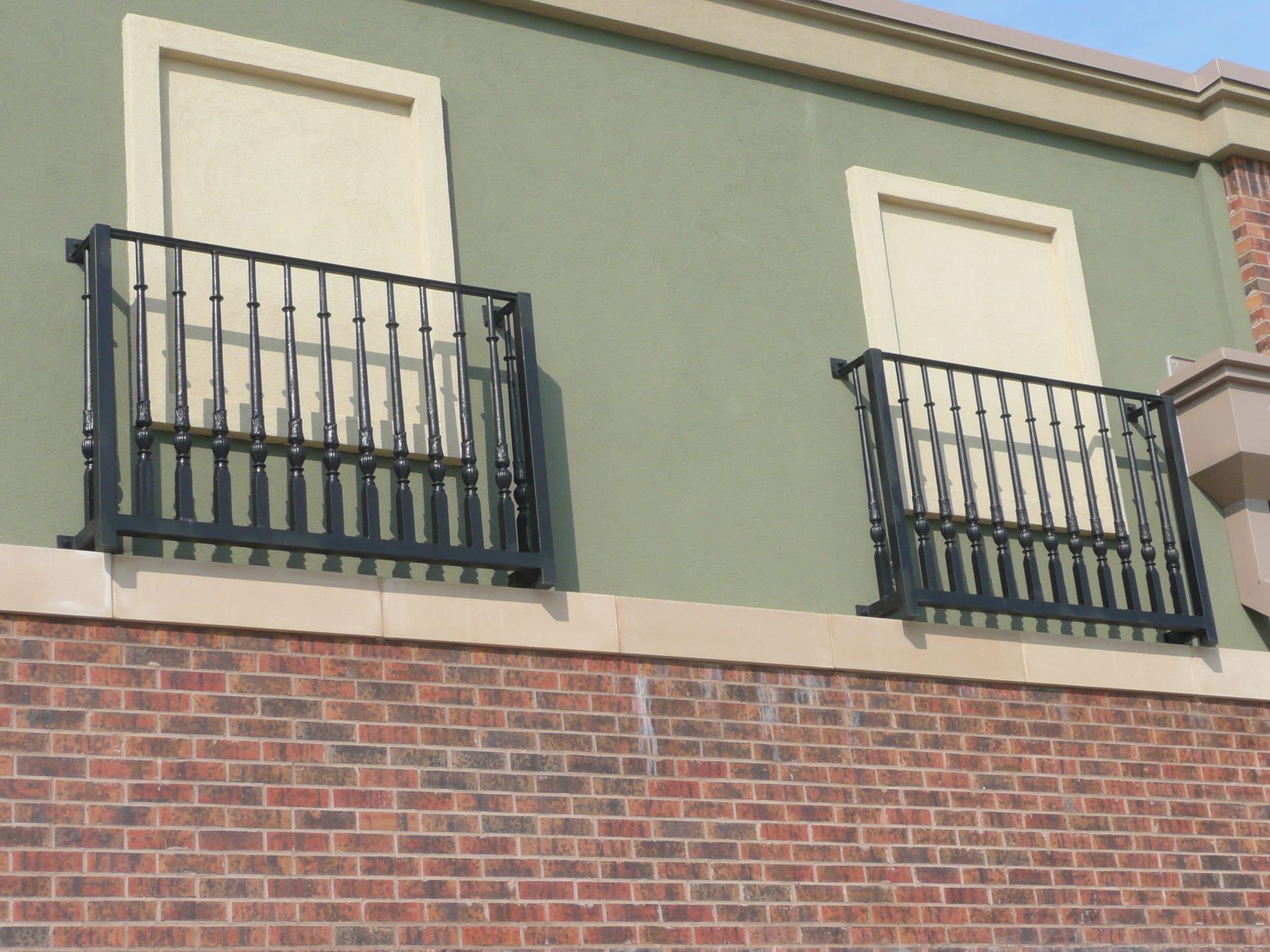 Two balconies on the side of a brick building