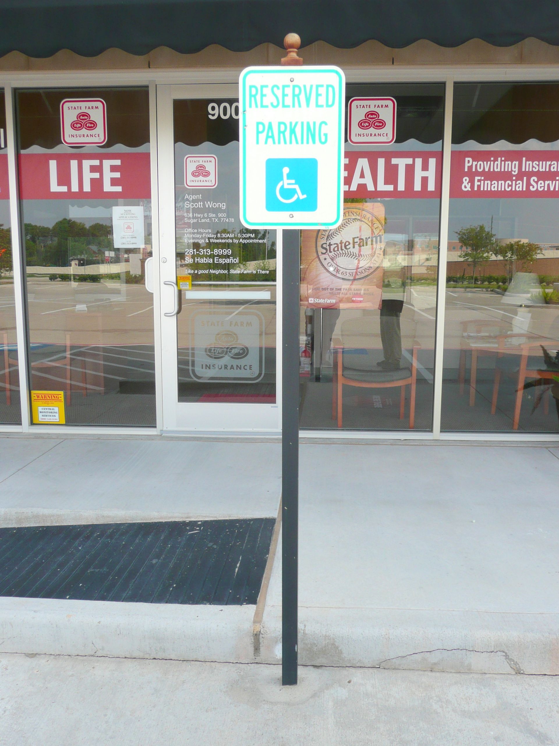 A reserved parking sign in front of a store