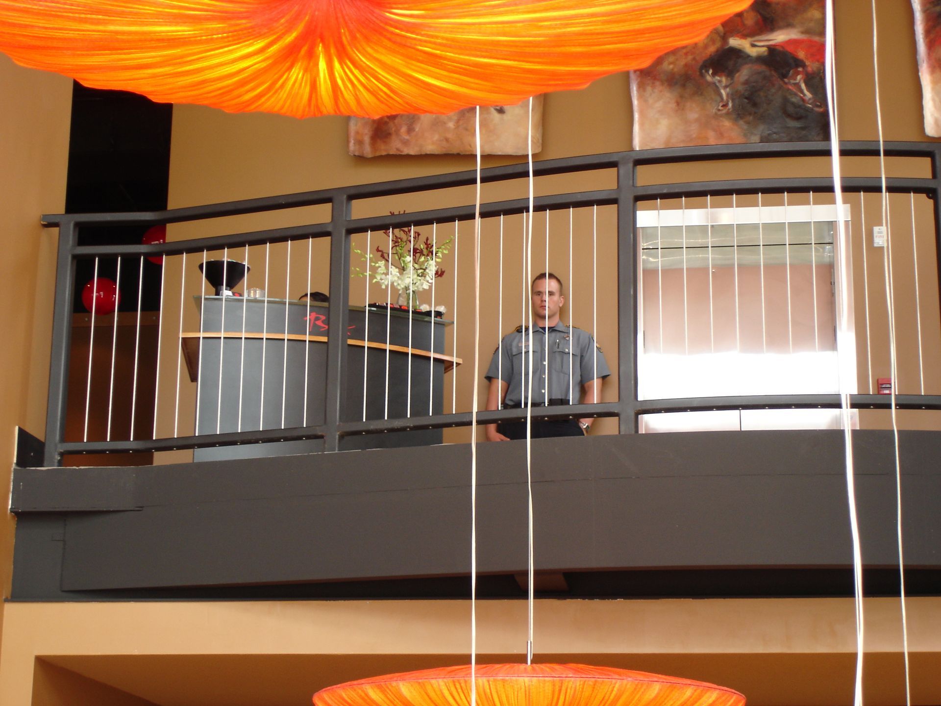 A man stands on a balcony with a podium in the background