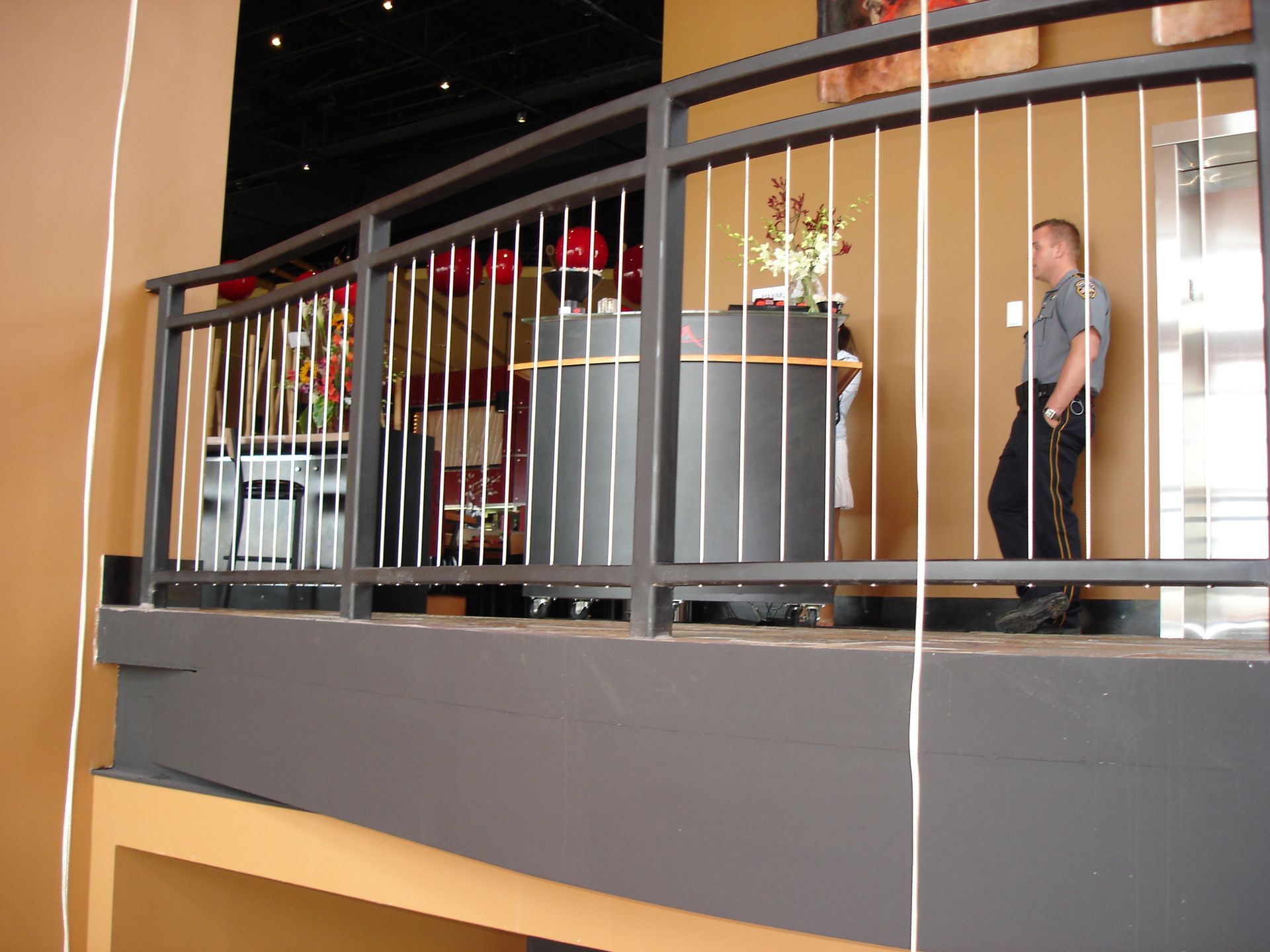 A man standing on a balcony with a metal railing