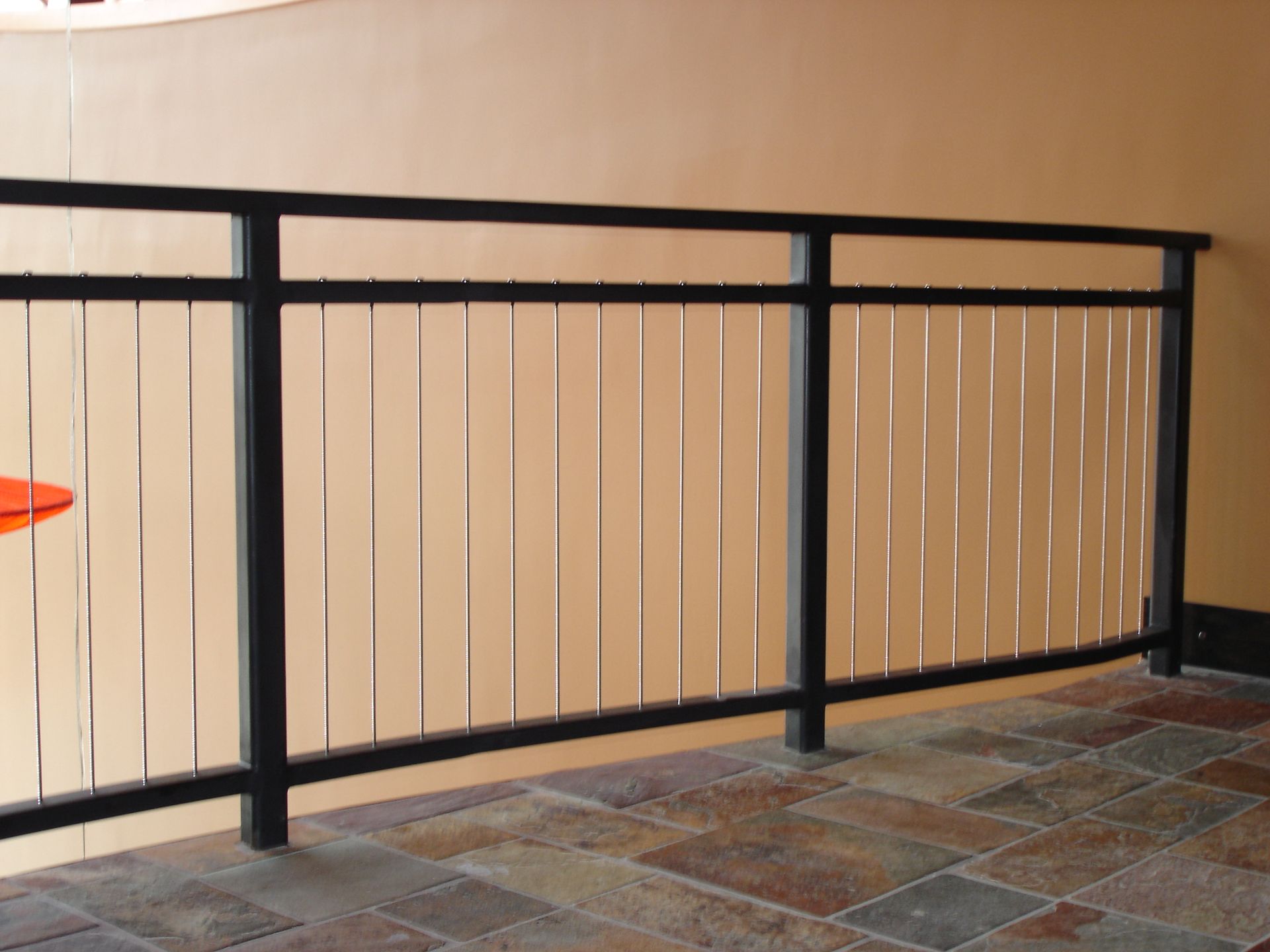 A balcony with a metal railing and a tiled floor