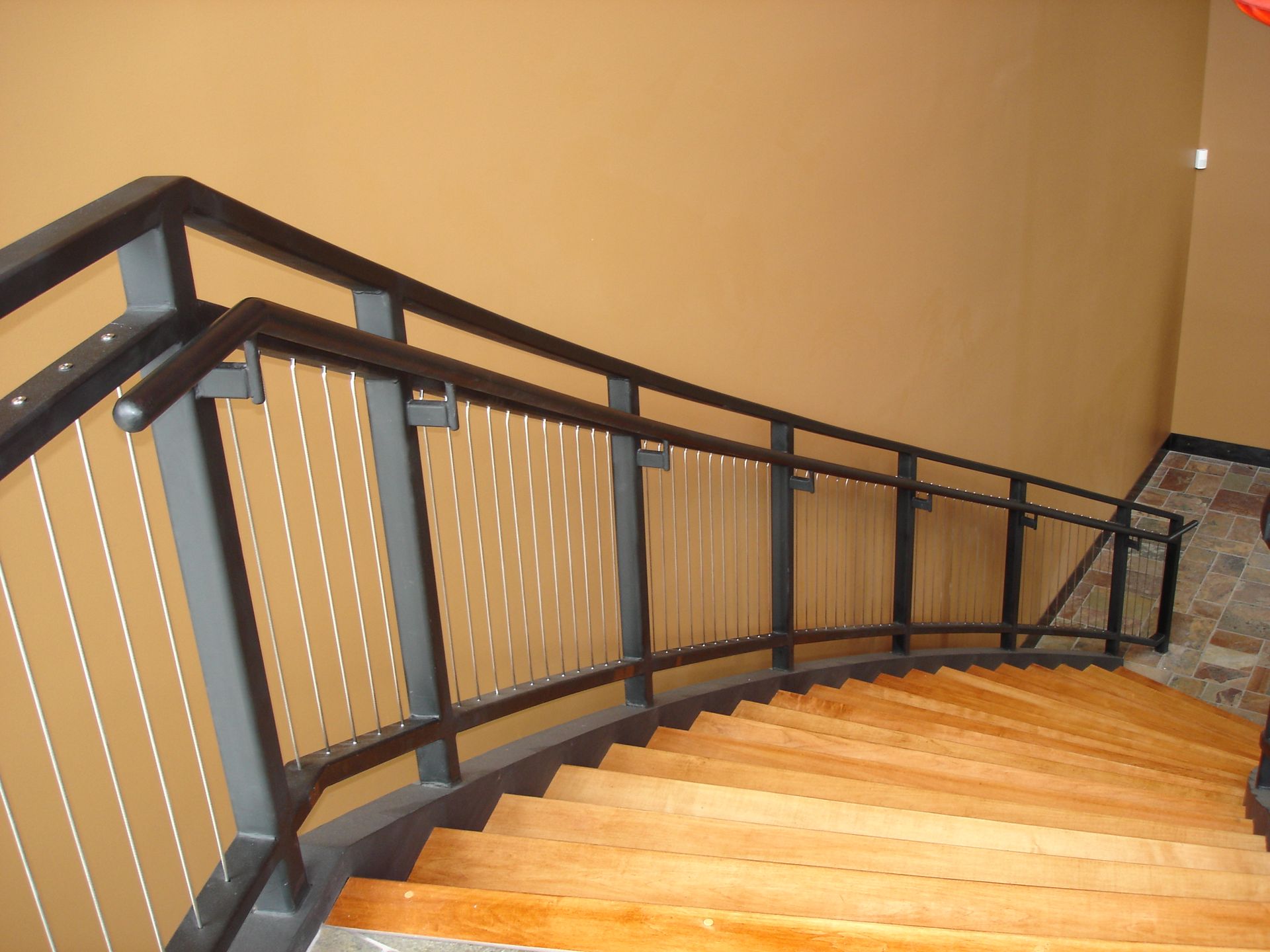 A staircase with a metal railing and wooden steps