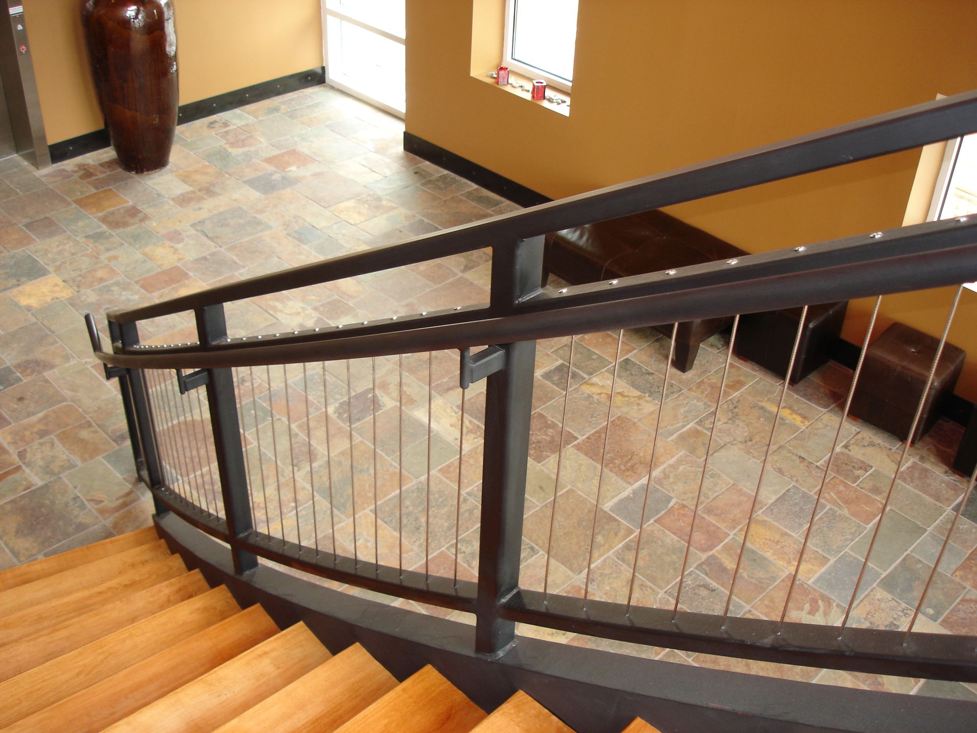 A staircase with a metal railing and wooden steps