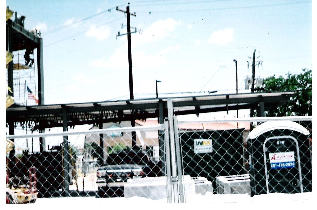 A chain link fence surrounds a building under construction