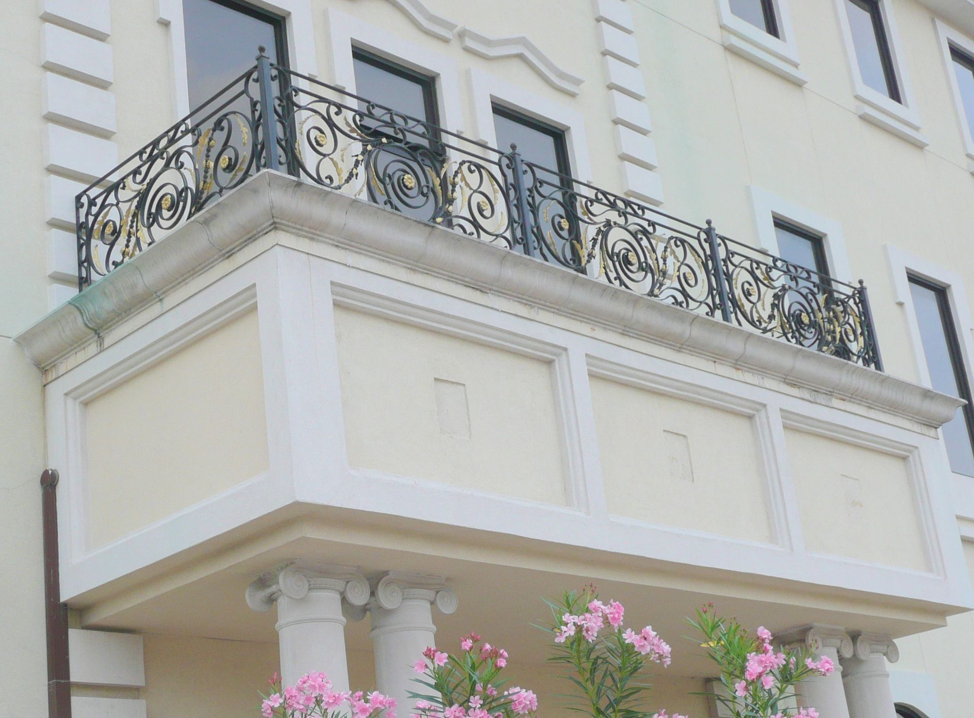 A balcony with a wrought iron railing on the side of a building.
