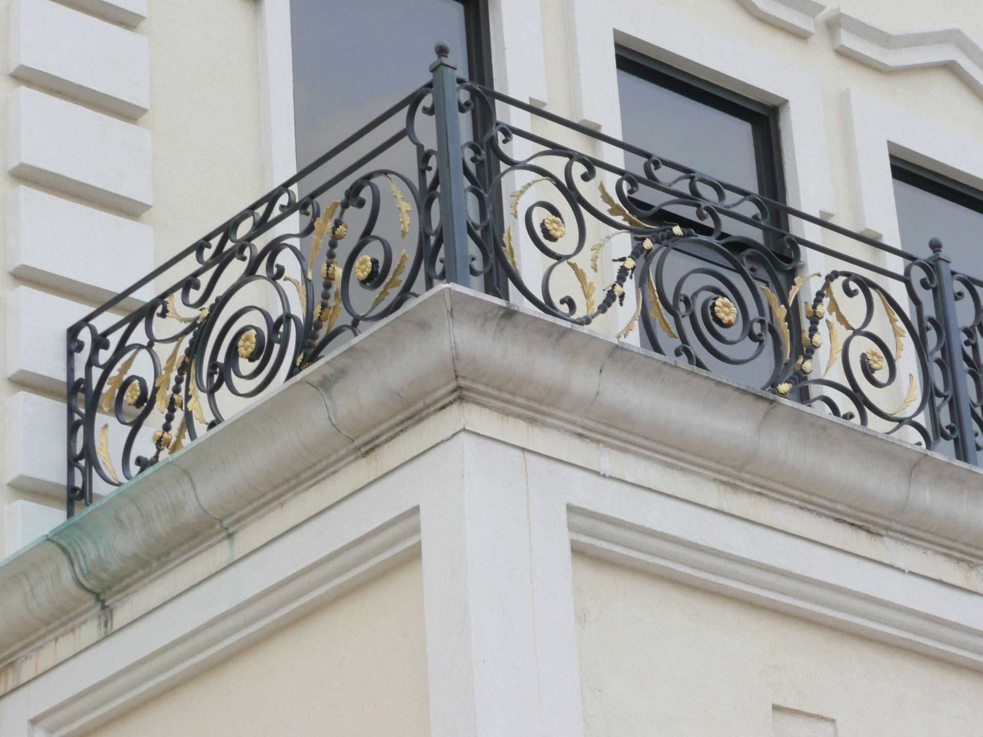 A balcony with a wrought iron railing on the side of a building