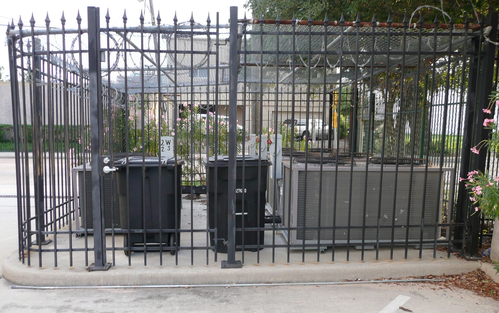 A wrought iron fence surrounds a parking lot