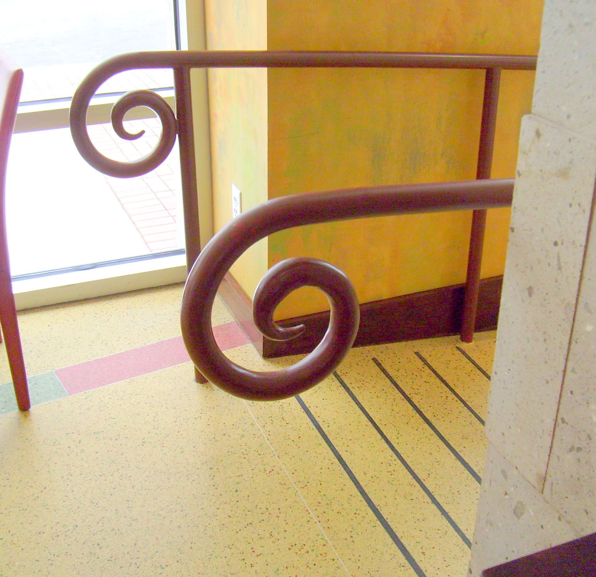 A stair railing with a swirl design on it