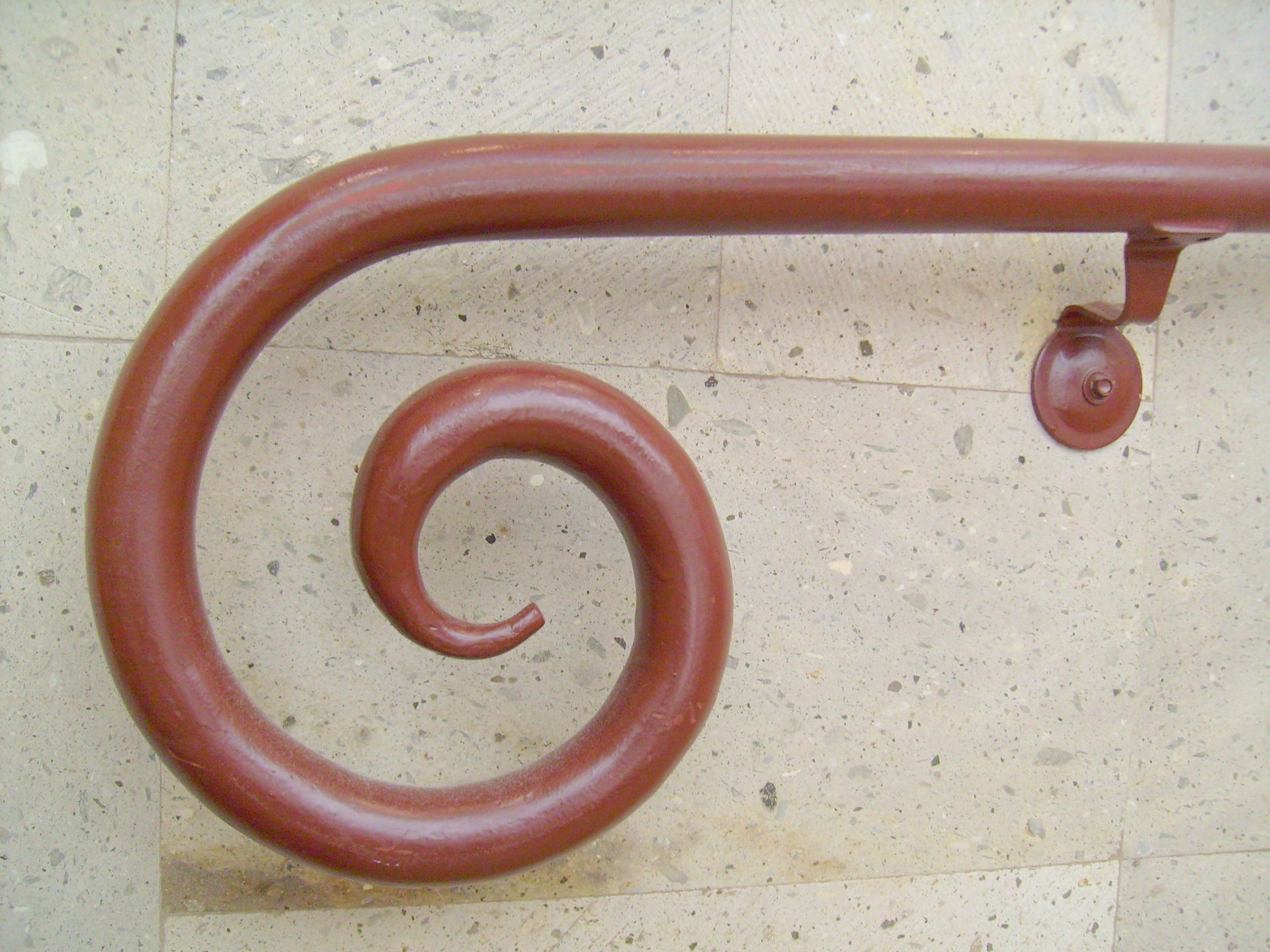 A red hand rail with a spiral design on it