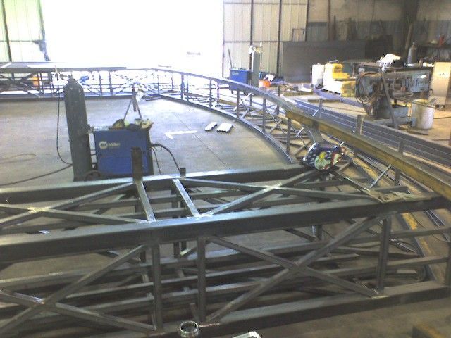 A large metal structure is being built in a factory