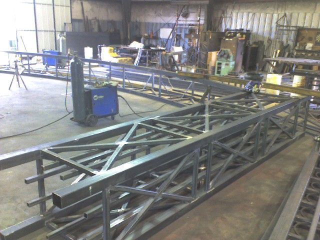 A large metal structure is being built in a factory