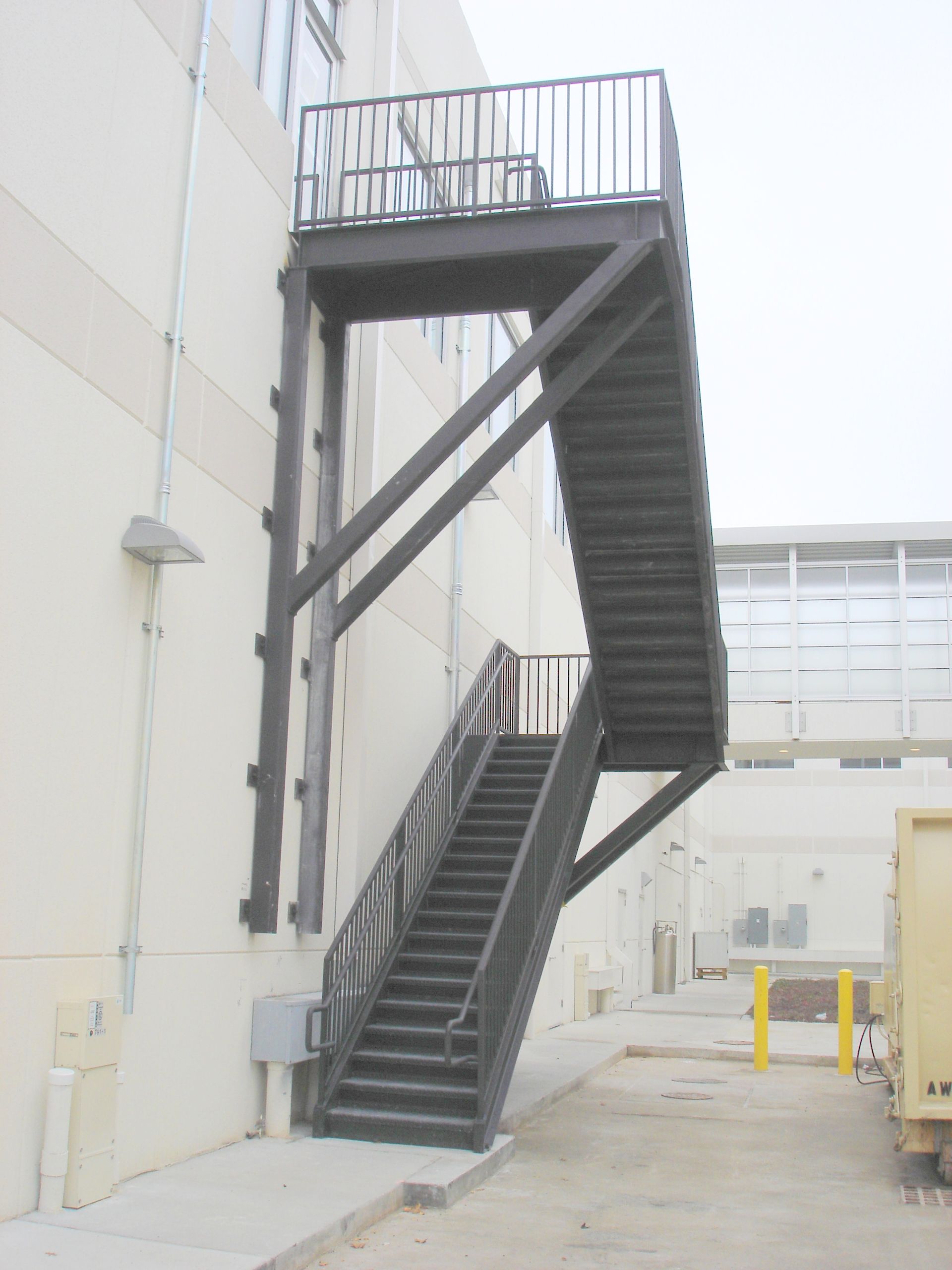 A set of stairs leading up to a balcony on the side of a building