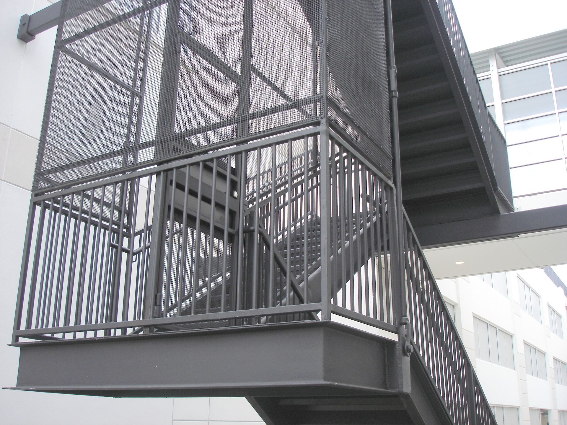 A set of stairs with a metal railing on the side of a building.