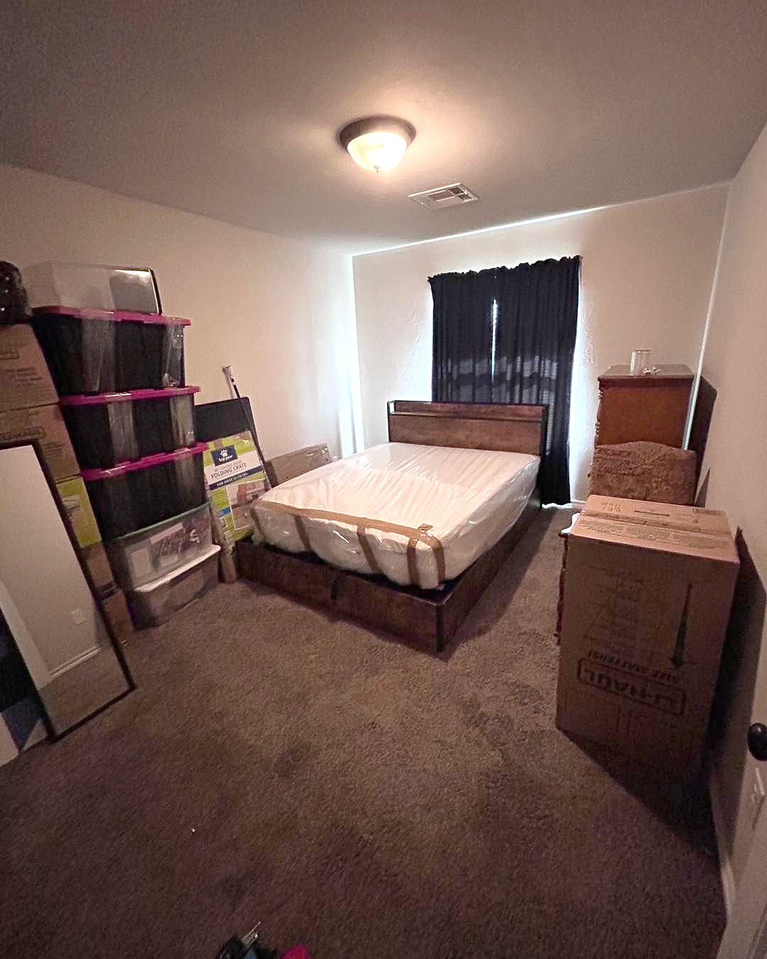 Man inside a moving truck. He is wearing shorts and a t-shirt. Boxes and belongings are inside.