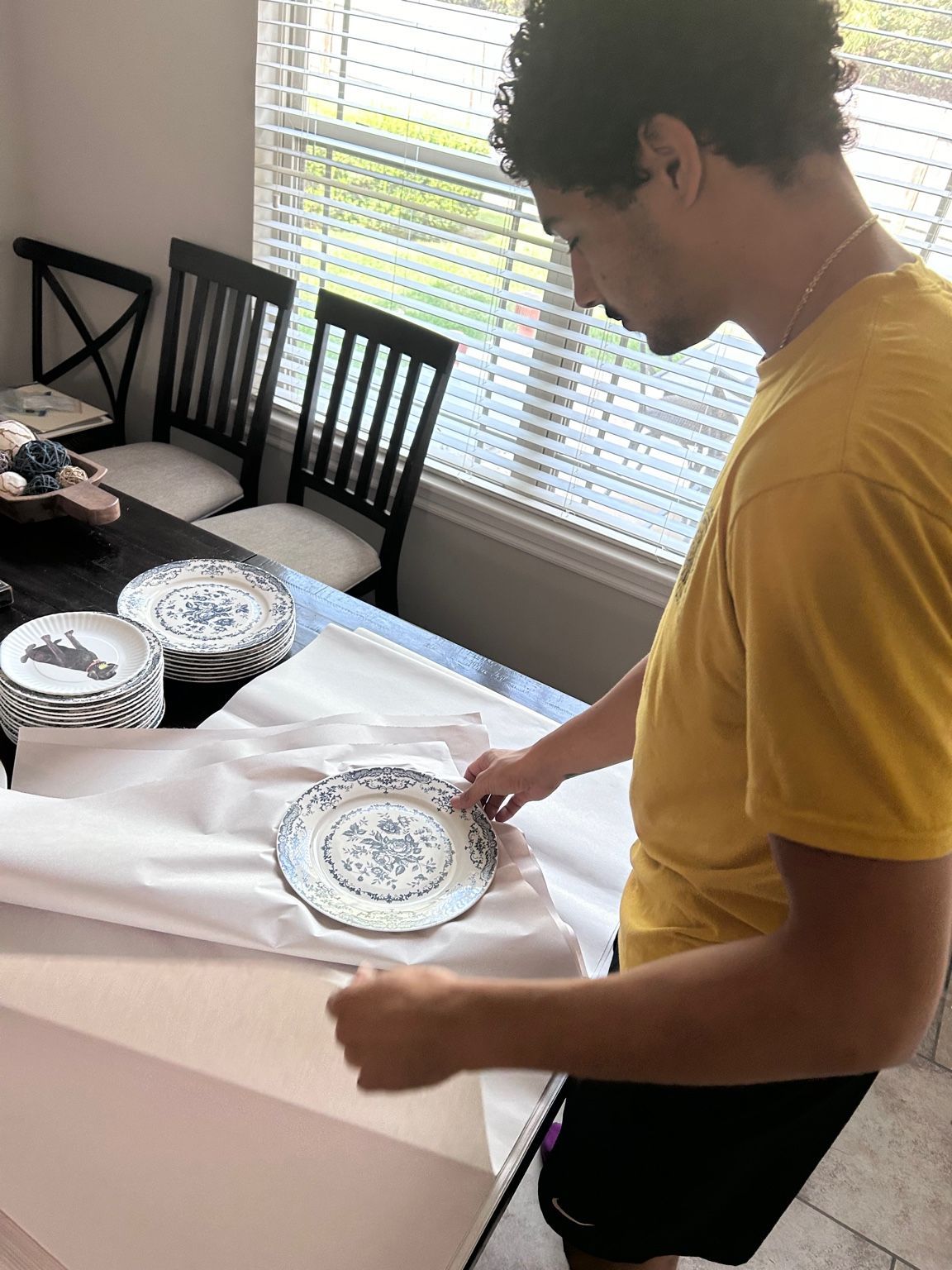 Person assembling a wooden dining table on a floor mat indoors.