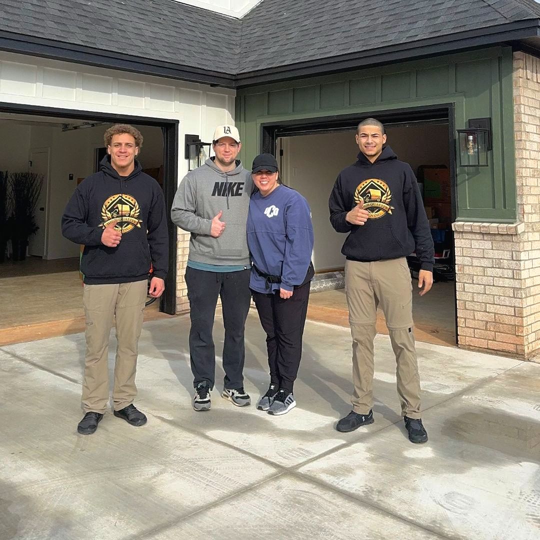 A group of people are posing for a picture in front of a new home.