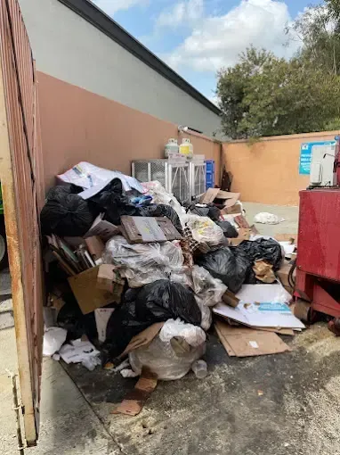 Two white display cabinets with glass shelves, near a chandelier and table.